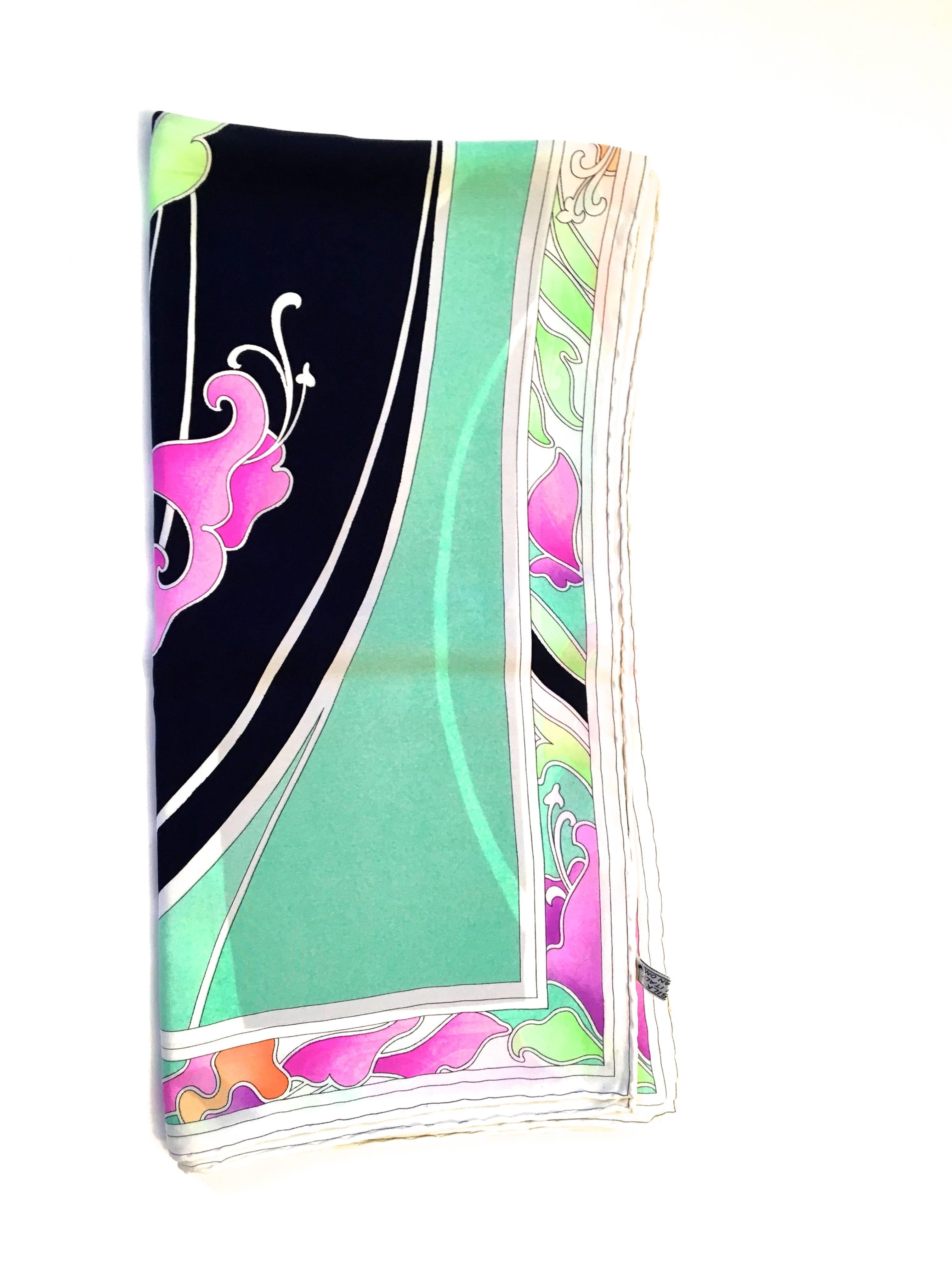 Presented here is a Leonard Scarf that is 100% silk. The scarf is a floral print that represents the Leonard brand beautifully. The scarf has a white border that is filled with a floral design. The main body of the scarf is a series of black, sea