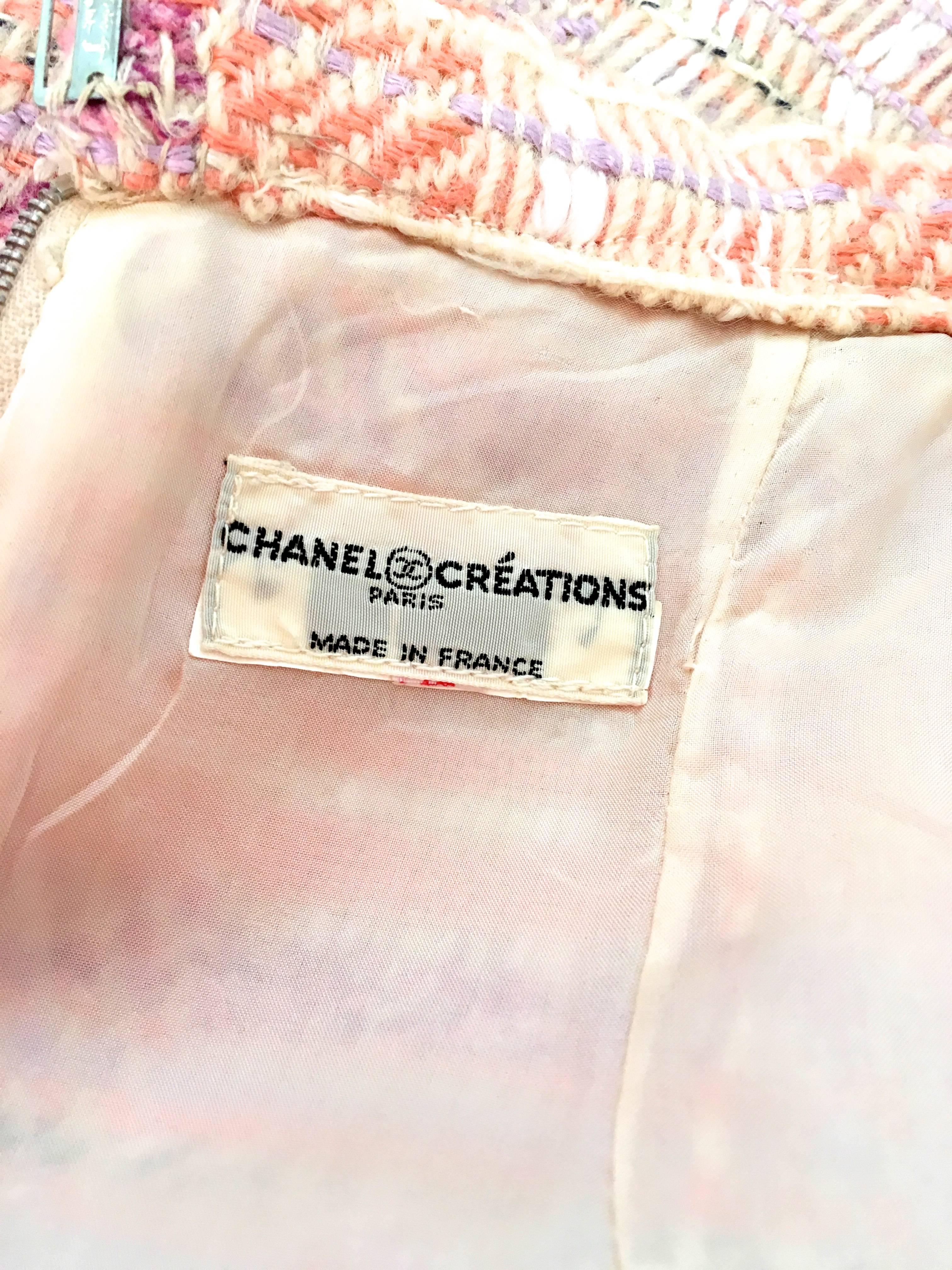 Presented here is an example of Chanel Creations at its finest. This vintage suit is a beautiful color combination of cream, peach, lilac and a little bit of a dark shade of purple with cream and white threading throughout with minor hints of black