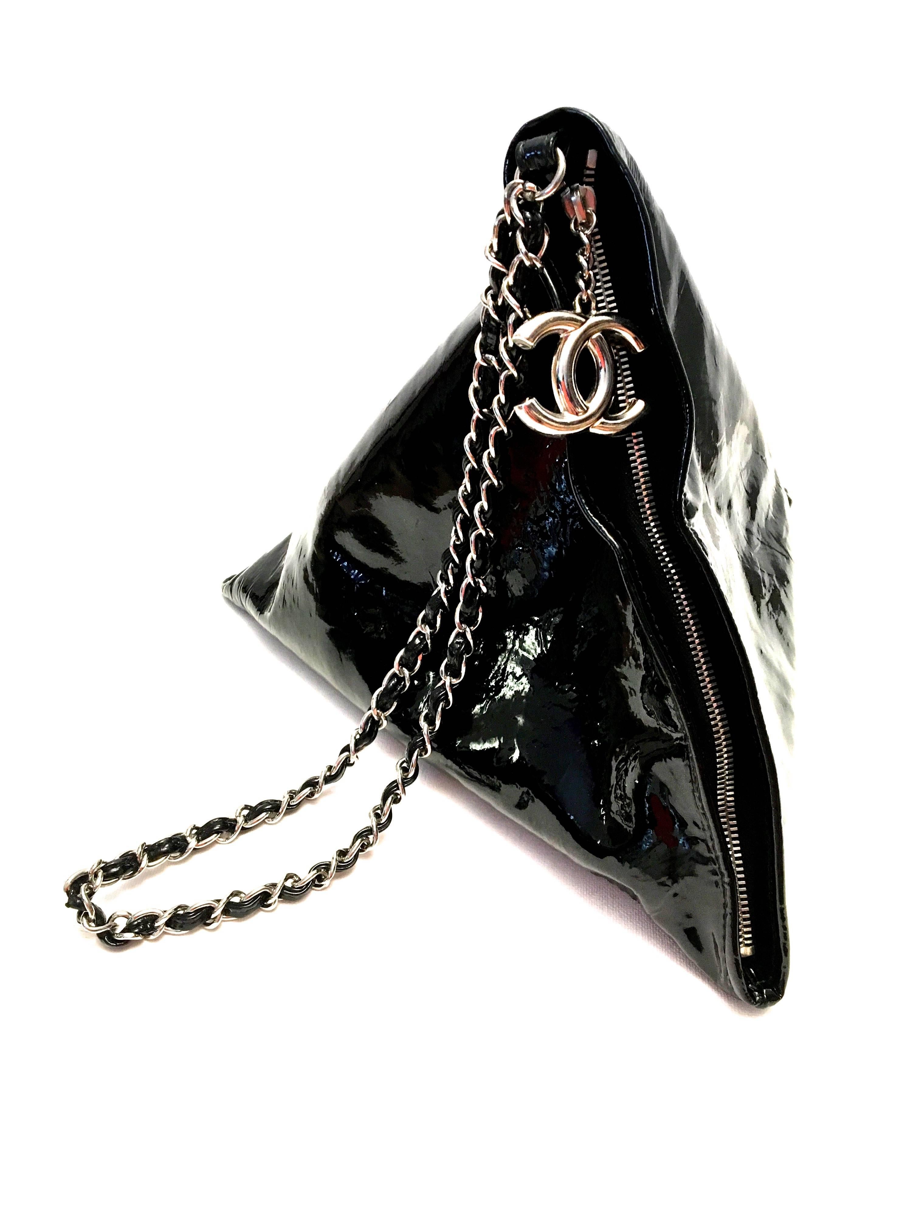Presented here is a black triangular purse from the 1980's. The purse is a solid black on the exterior in a triangular pyramid design. The purse has a zipper on one of the edges of the pyramid so it can be very comfortably worn on the shoulder.  The