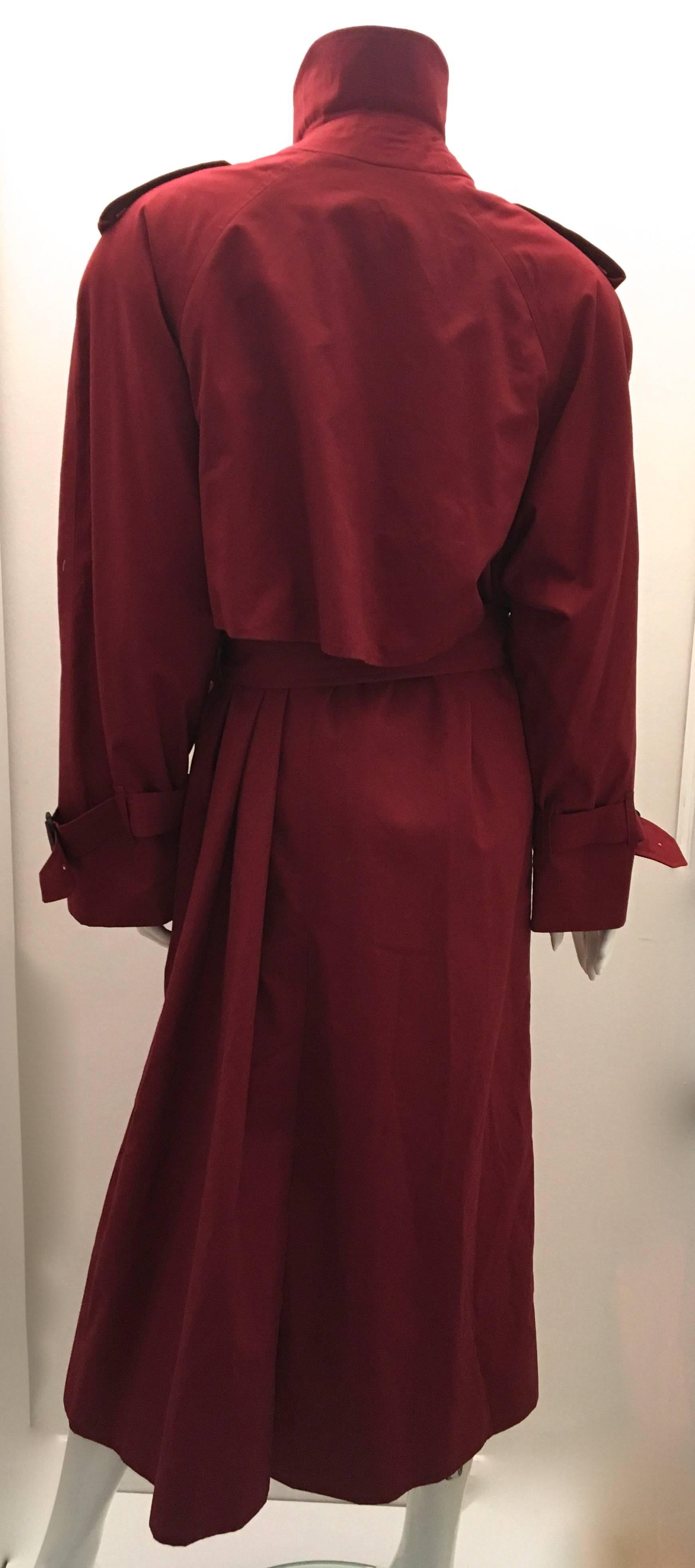 Presented here is a magnificent raincoat from Burberrys. The coat is made from 100% cotton and is a size 12 long. The coat is burgundy colored and is lined with the trademark Burberry pattern on the interior of the coat. The inside trademark fabric