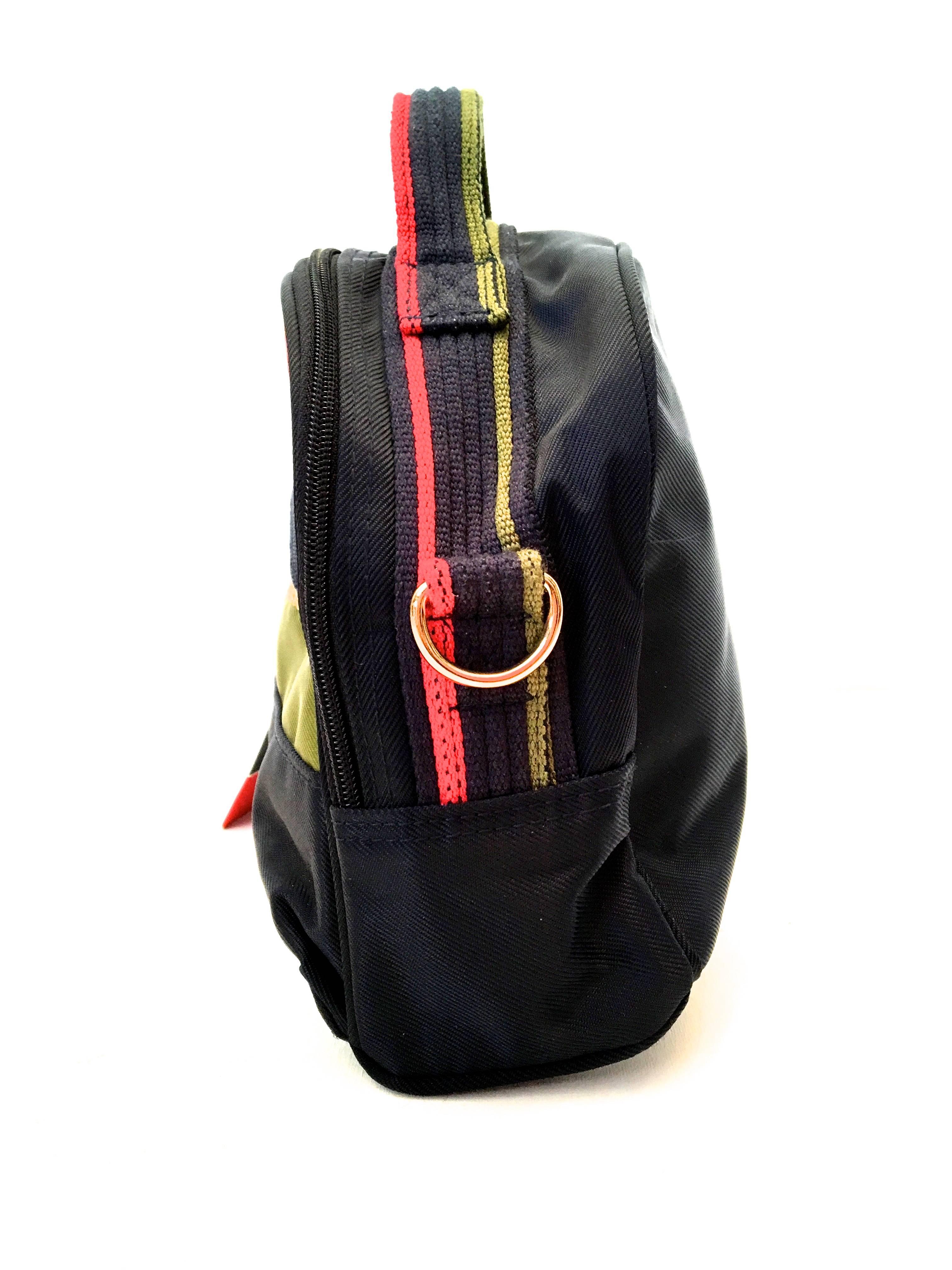 Presented here is a rare Roberta di Camerino nylon shoulder bag. The bag is comprised of red, green and navy blue colors in nylon fabric. There is a gold tone Roberta di Camerino emblem on the exterior of the bag. The bag has a main large pocket and