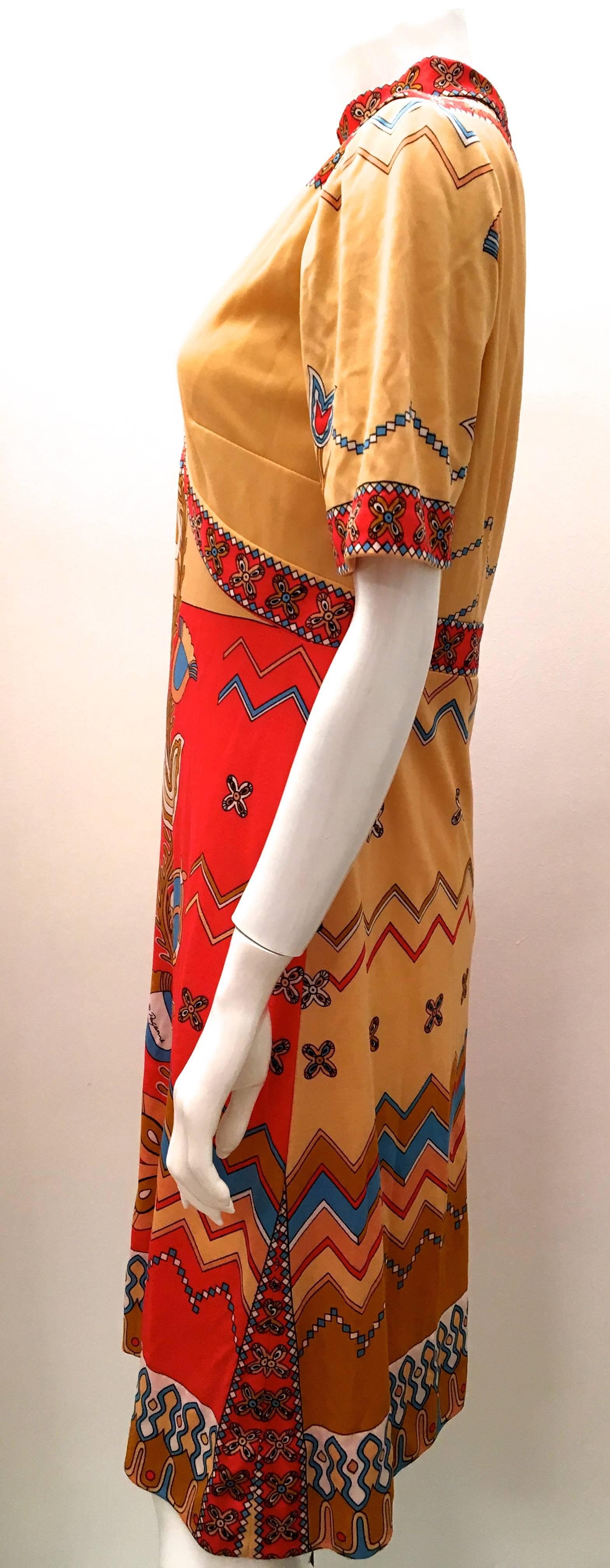 Presented here is a gorgeous Paganne day dress from the 1970's. The dress is a geometric graphic floral print comprised of shades of yellow, cream, orange, red, white and blue. There is no fabric label attached, but the fabric has some stretch like