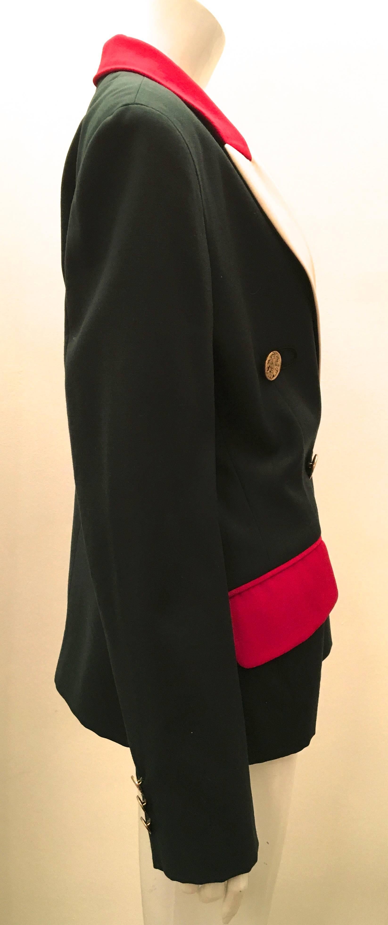 Presented here is a magnificent blazer from Moschino. The blazer is a forest green color  with each of the two pocket flaps on the front of the blazer with red fabric. The lapels are a creamy beige and the color of the color transitions to red as it