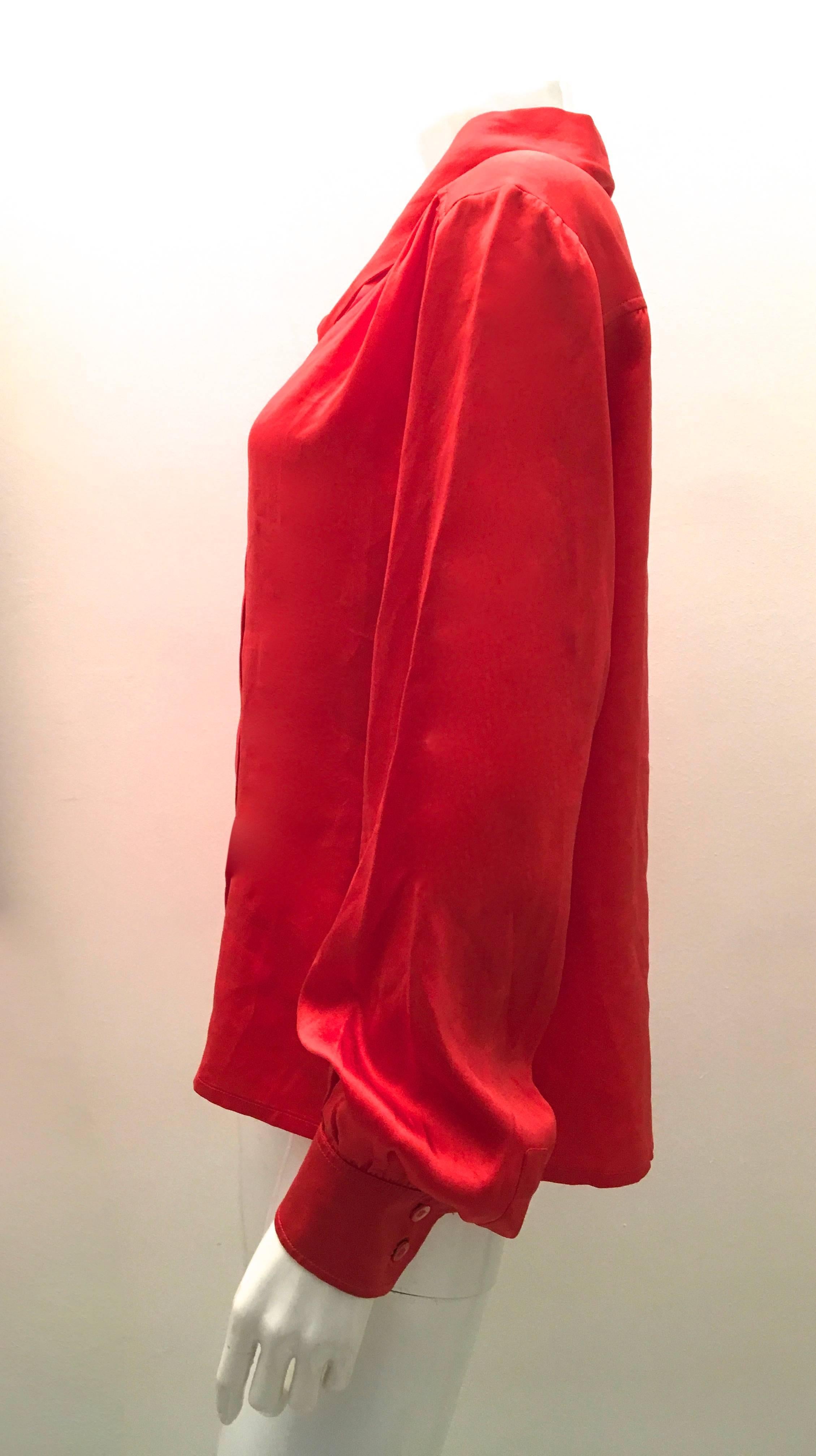 Presented here is a Celine blouse. The blouse is made of 100% silk and is a red / orange coloring. The blouse has a this wrap around scarf that is sewn into the blouse. The scarf can be worn as a tie or as a small scarf depending upon desired look.