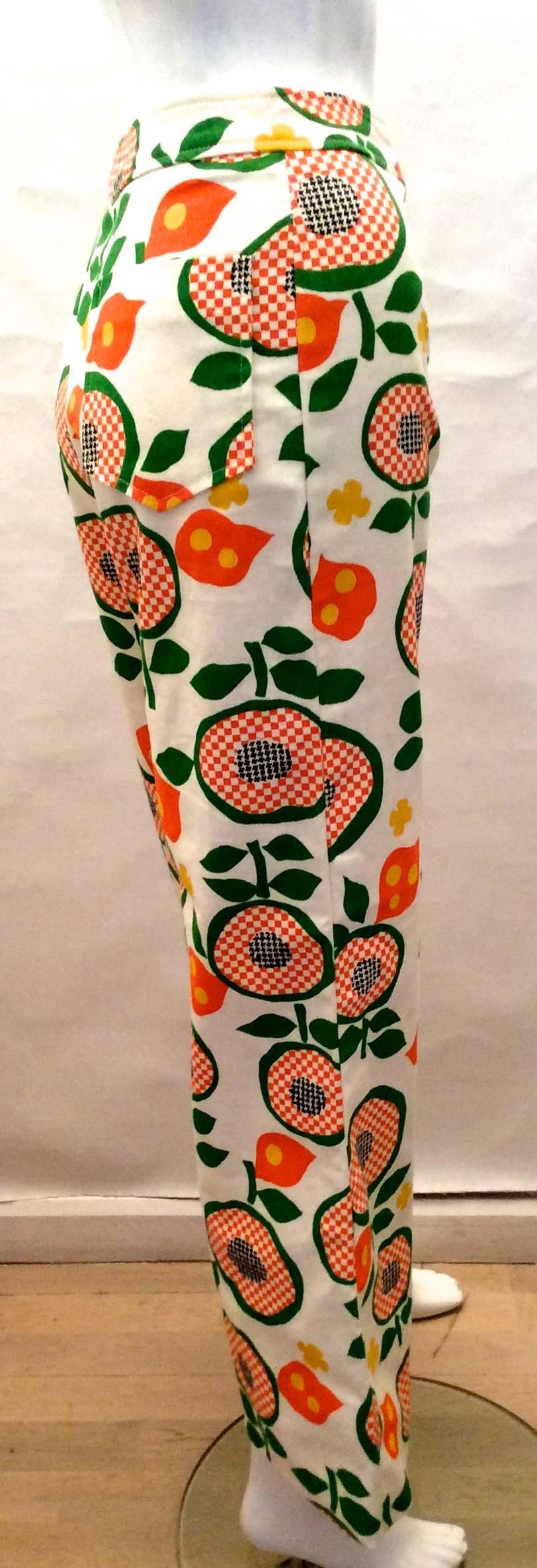 Presented here is a pair of beautiful bell bottom pants. The pants are from the 1970’s. The print is a floral print on a white denim. The print consists of flowers with green, yellow, orange and black colors. The pants are in excellent condition.