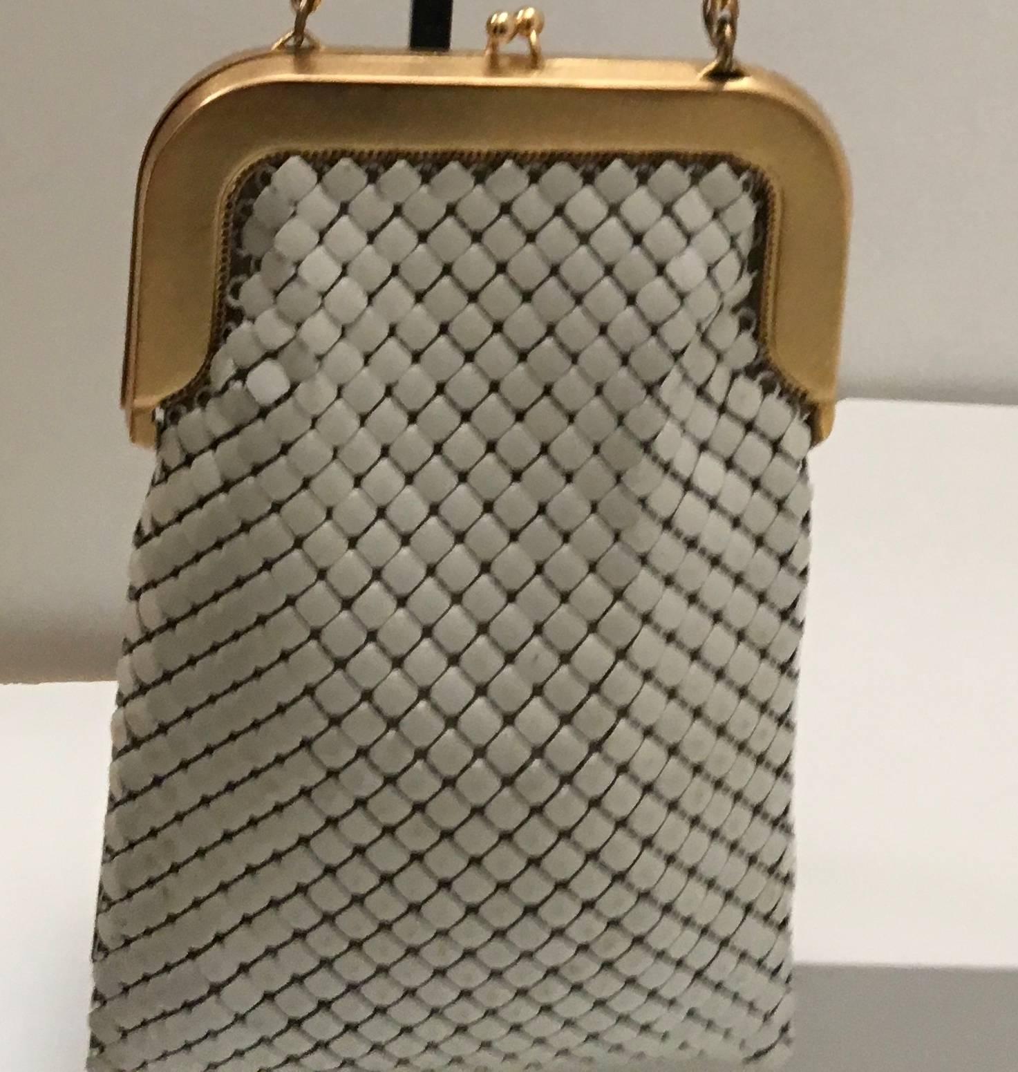 Presented here is a beautiful vintage Whiting and Davis white mesh evening bag from the 1970's. The purse is comprised of a beautiful shiny white tone metal coloring on the exterior of the bag. The gold tone metal chain is 30 inches long. The purse