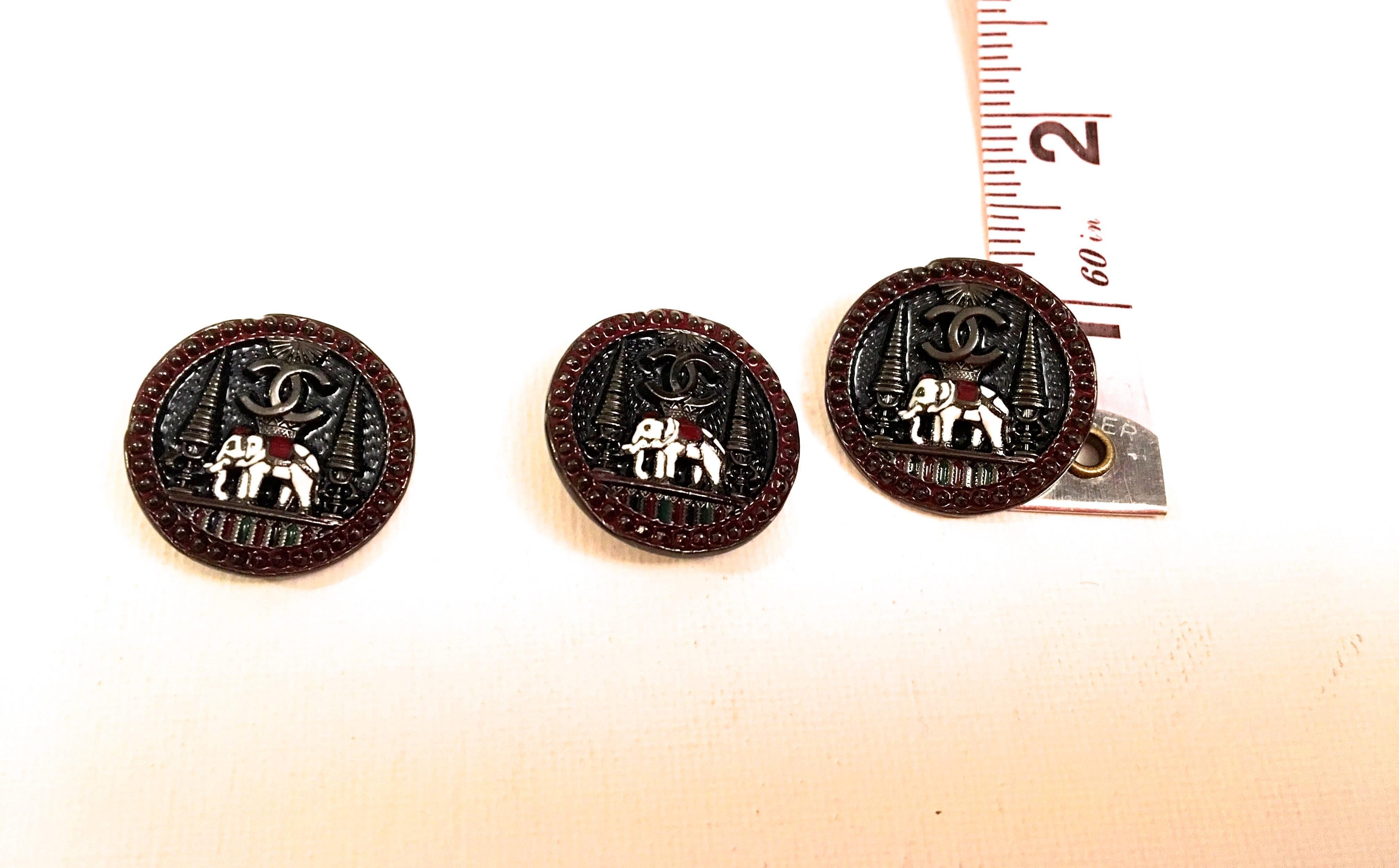 Presented here is a beautiful set of buttons from Chanel. Each button in the set is comprised of an elephant surrounding by decorative cones in the background. Each button is signed on the front with the iconic Chanel CC logo. The reverse of each