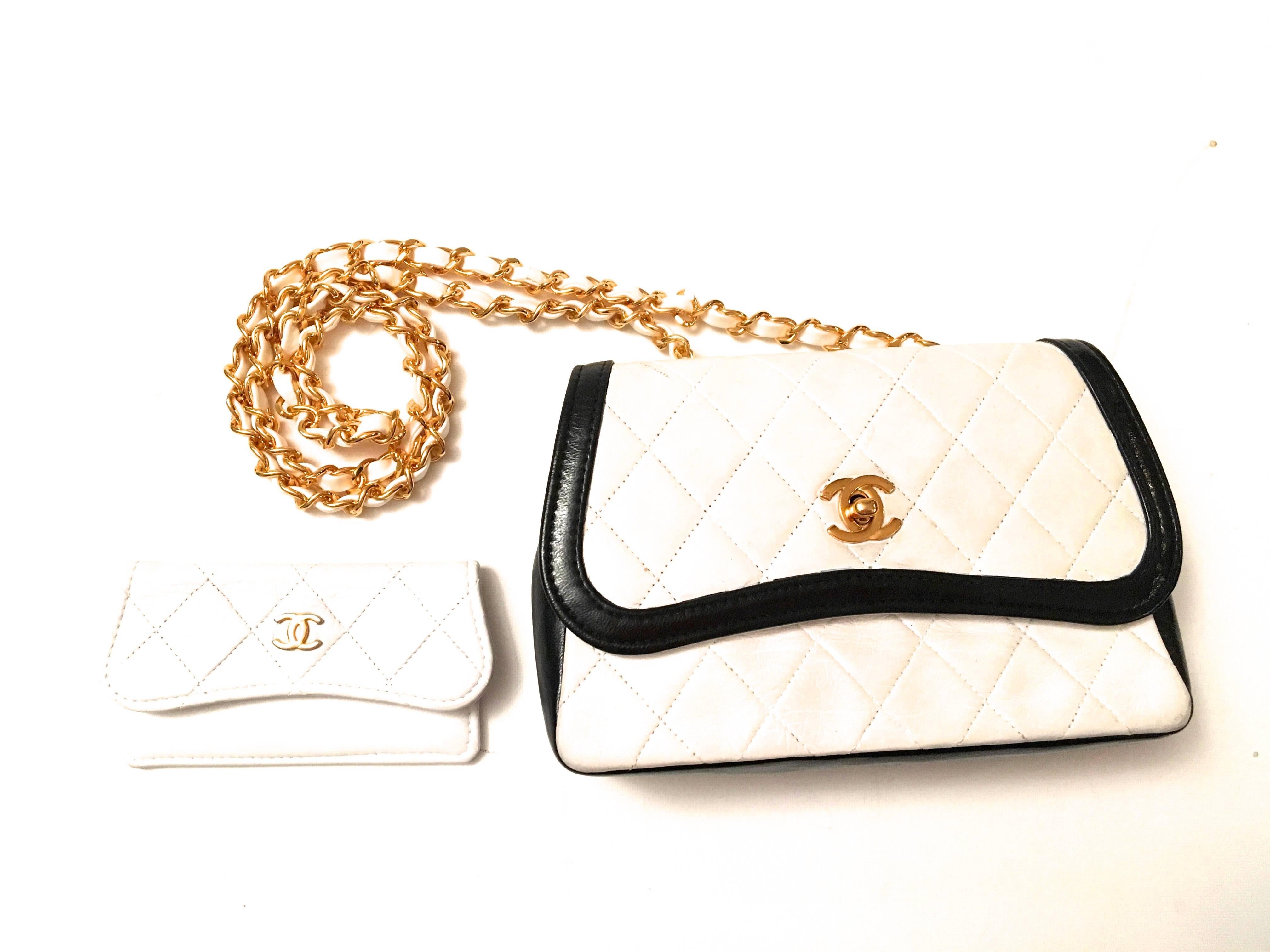 Presented here is a beautiful black and white crossbody bag from Chanel. The purse is from the late 80's early 90's. The bag is constructed with a beautiful classic white leather on the front, top and exterior. The bag is trimmed in black leather