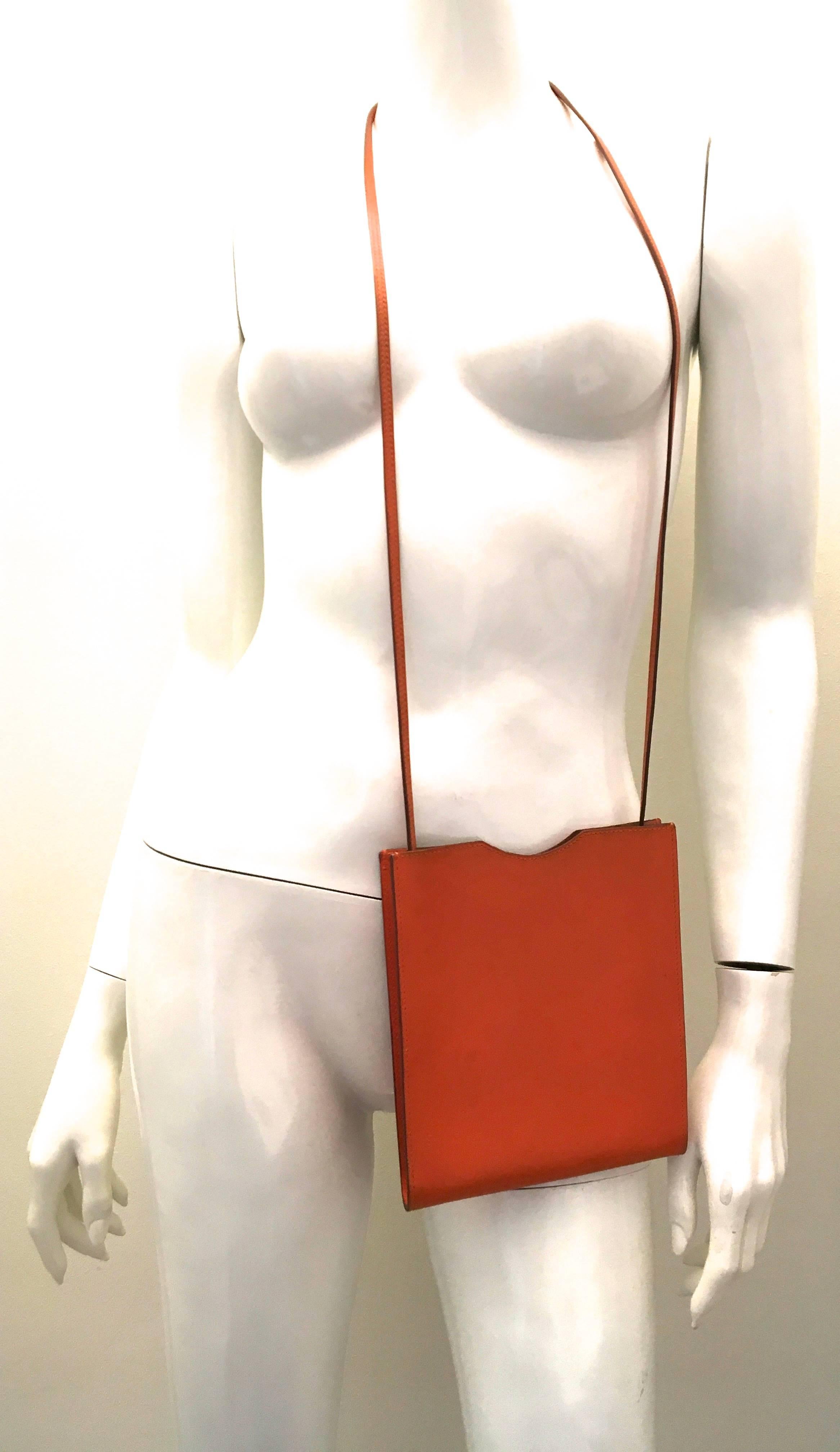 Presented here is a beautiful cross body purse from Hermes. The bag is a singular leather pouch that has one compartment with sufficient room for basic essentials. The soft grain of leather is a rich orange color. The bag is in excellent condition
