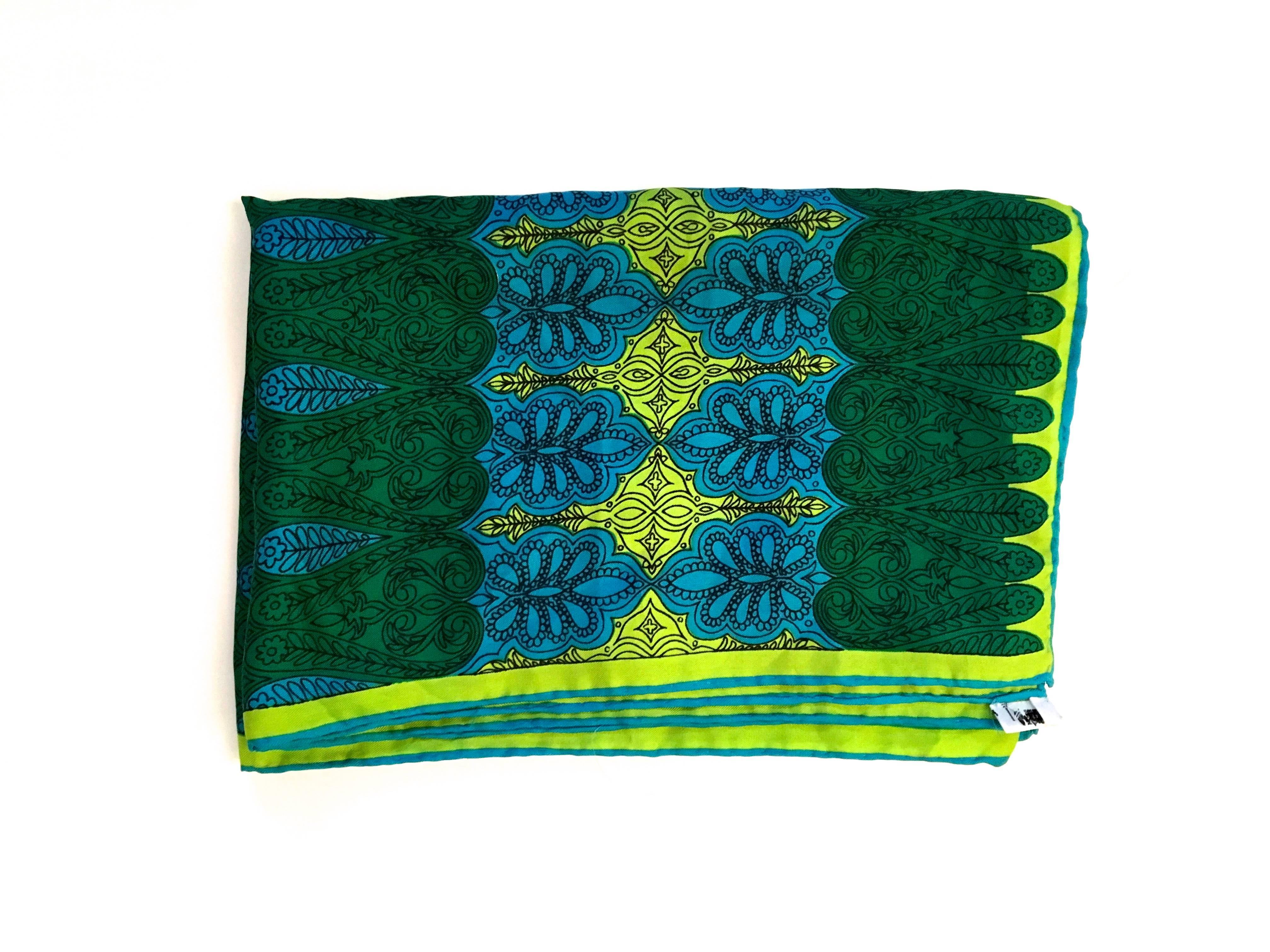 Presented here is a beautiful vintage scarf from Vera from the 1960's. The scarf is hand rolled and made from 100% silk. The design is a stylized filigree design with varying shapes throughout. The scarf has colors of black, lime green, green and