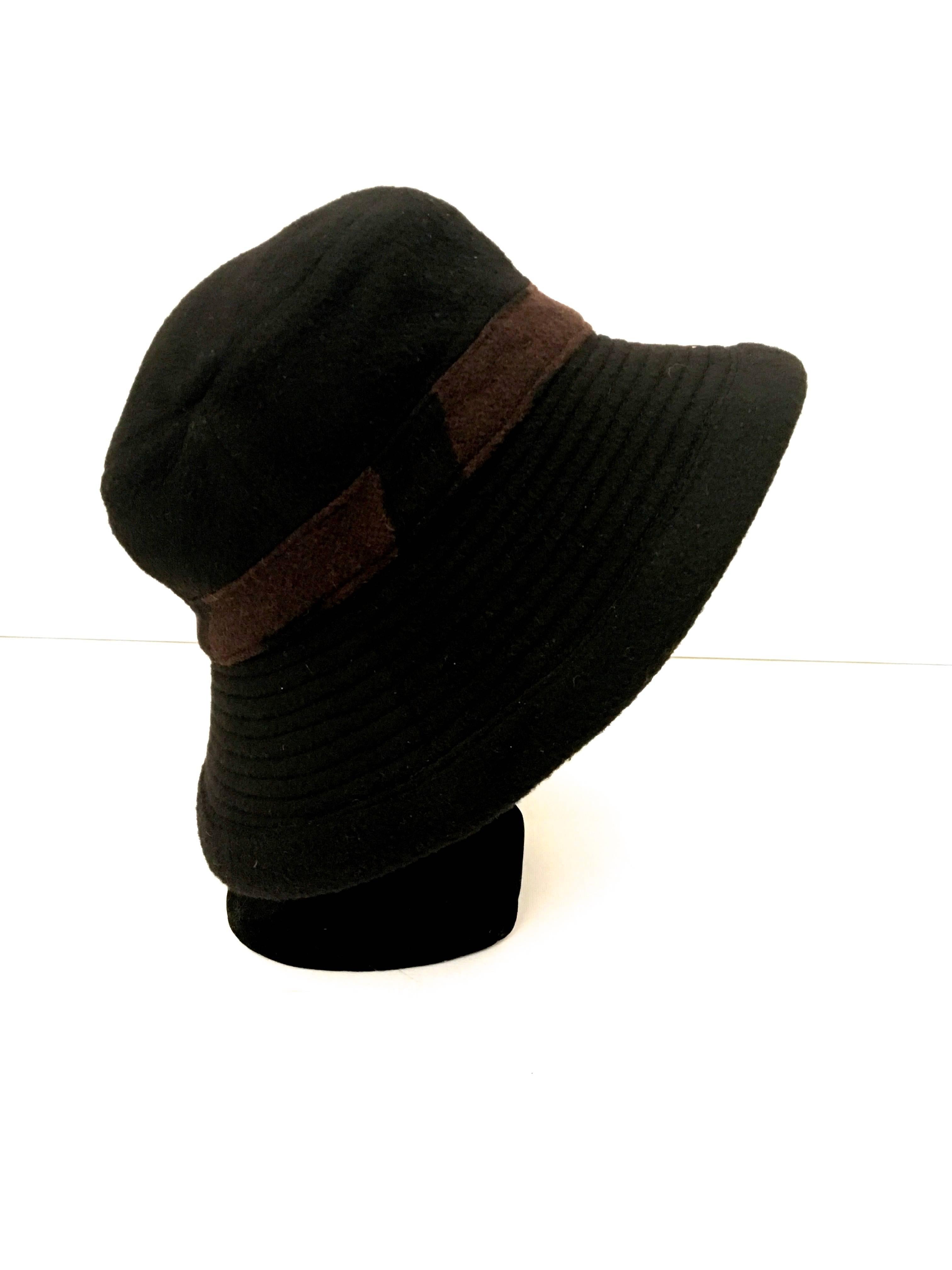 Presented here is a beautiful hat from Hermes Paris. This beautiful black hat is made from 100% camel’s hair. There is a brown and black patterned band around the crown of the hat. The hat can be worn down or with the brim up. When worn down, the