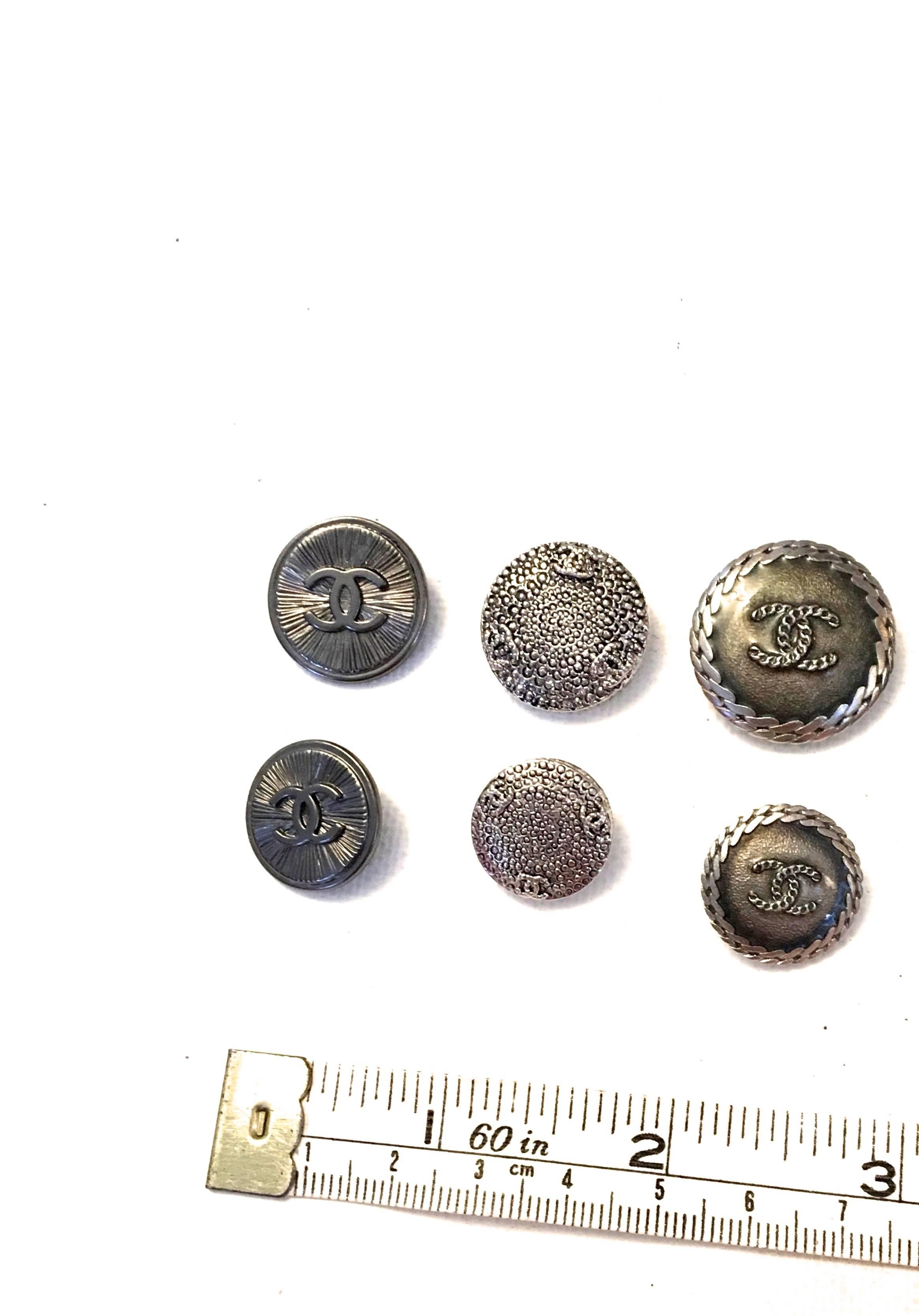 Presented here is an assorted lot of 14 Chanel buttons. In the lot there are 7 different designs. Among those 7 designs there is one large and one smaller version of the same design. 

The designs are as follows:
- Large and small silver tone and