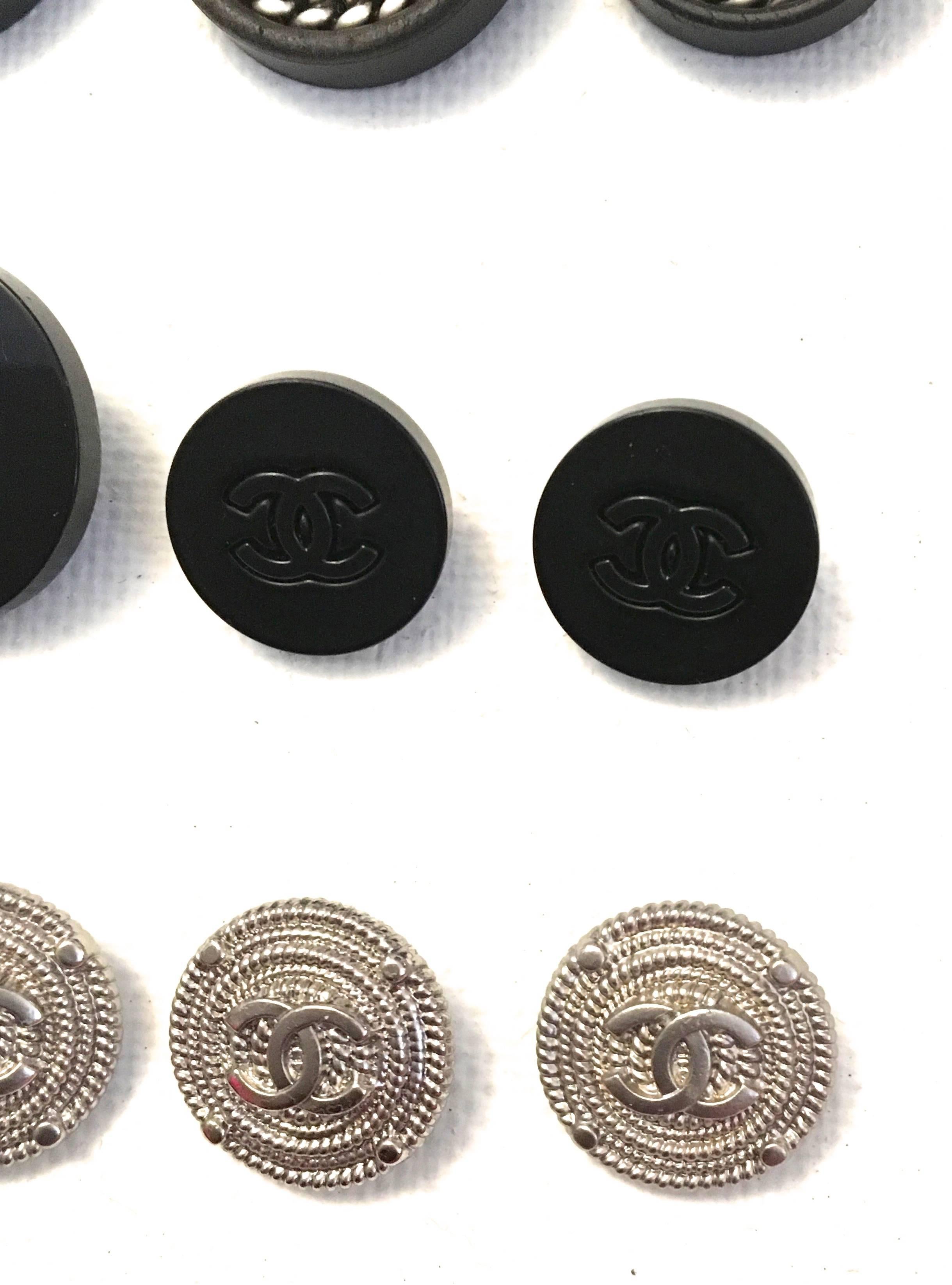 Presented here is a magnificent collection of 12 Chanel Buttons.  

The first 3 buttons comprise 3 matching black buttons. The two larger are black and surrounded by a silver chain with a CC logo in the center. The larger are .9 inches in diameter.