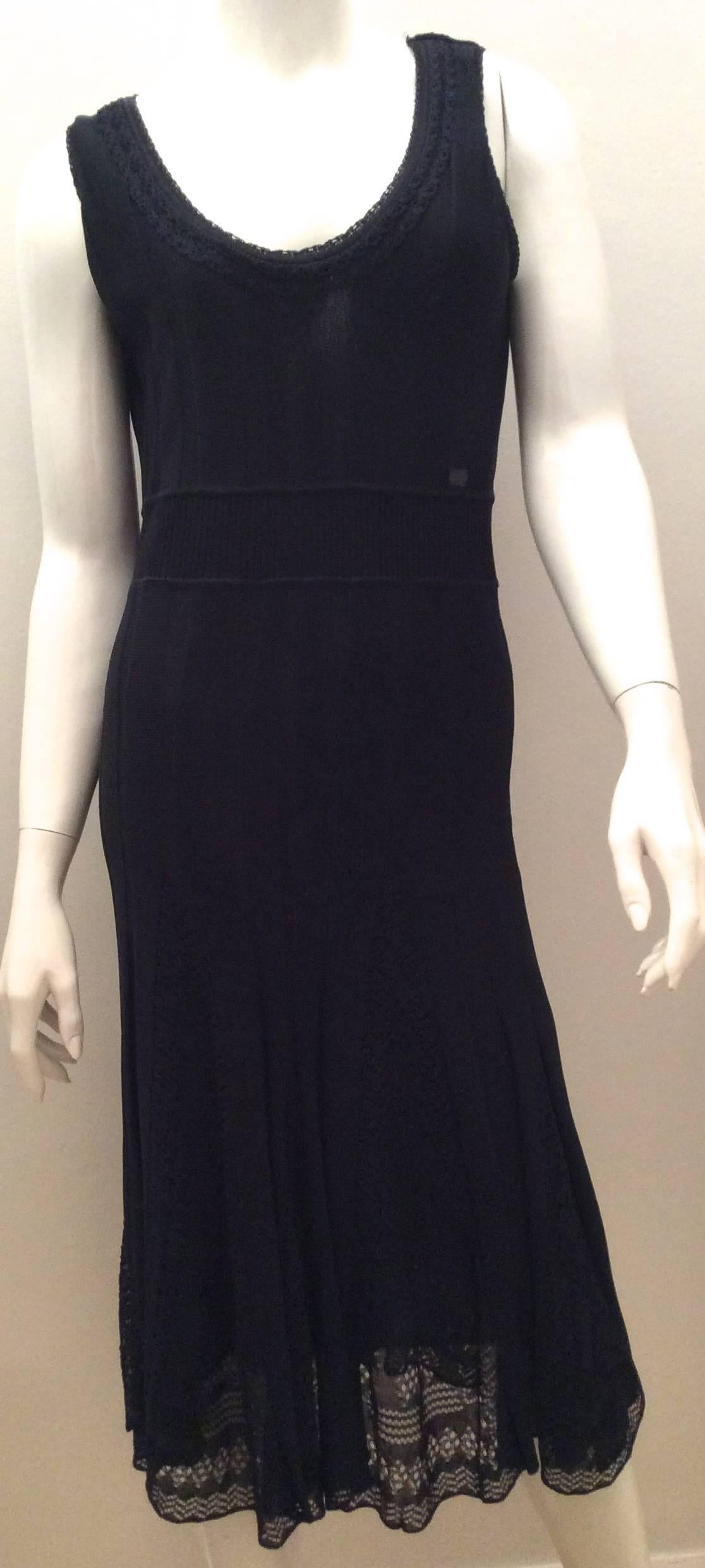 Presented here is a magnificent navy knit Chanel dress that is extremely flattering. This sleeveless dress has stripes down the front and 2.5 inches of knit centerpiece with the black Chanel logo on the top of the inch piece spelling out Chanel,