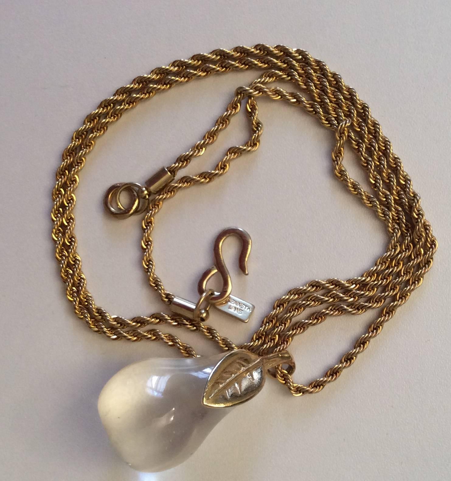 Presented here is a Kenneth J. Lane (KJL) lucite pear necklace. The lucite pear has two gold tone leaves and hangs from a 32 inch gold tone necklace. The necklace has a Kenneth J. Lane tag. It appears to have never been worn. I'm not sure of the