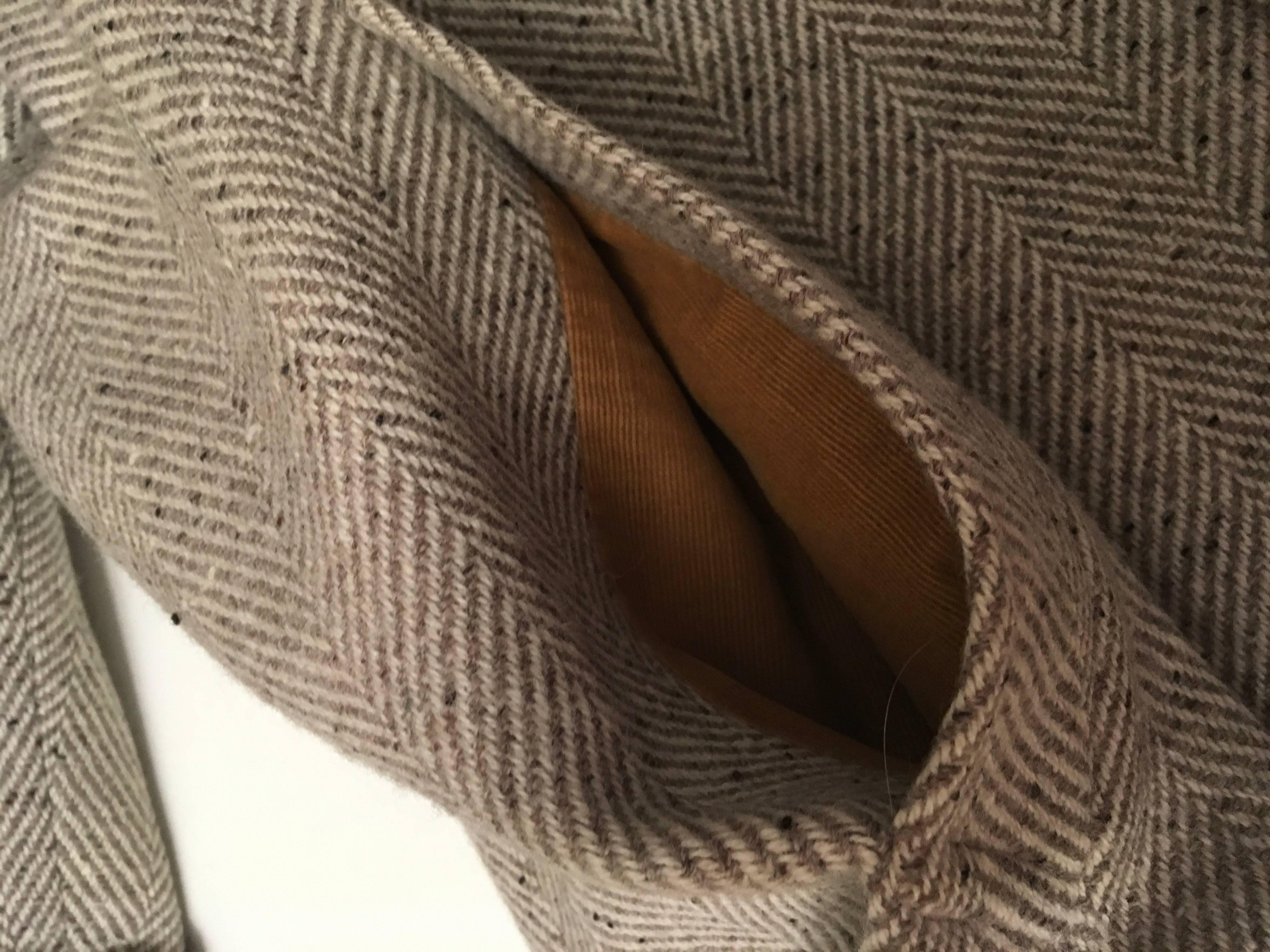 Presented here is a beautiful men’s vintage Hermes coat from the 1980’s. The coat was worn 2 times. The wool fabric is a beautiful gray herringbone of cream and taupe with speckles throughout. The sizing is a French 54. It is made in Italy.

It is a