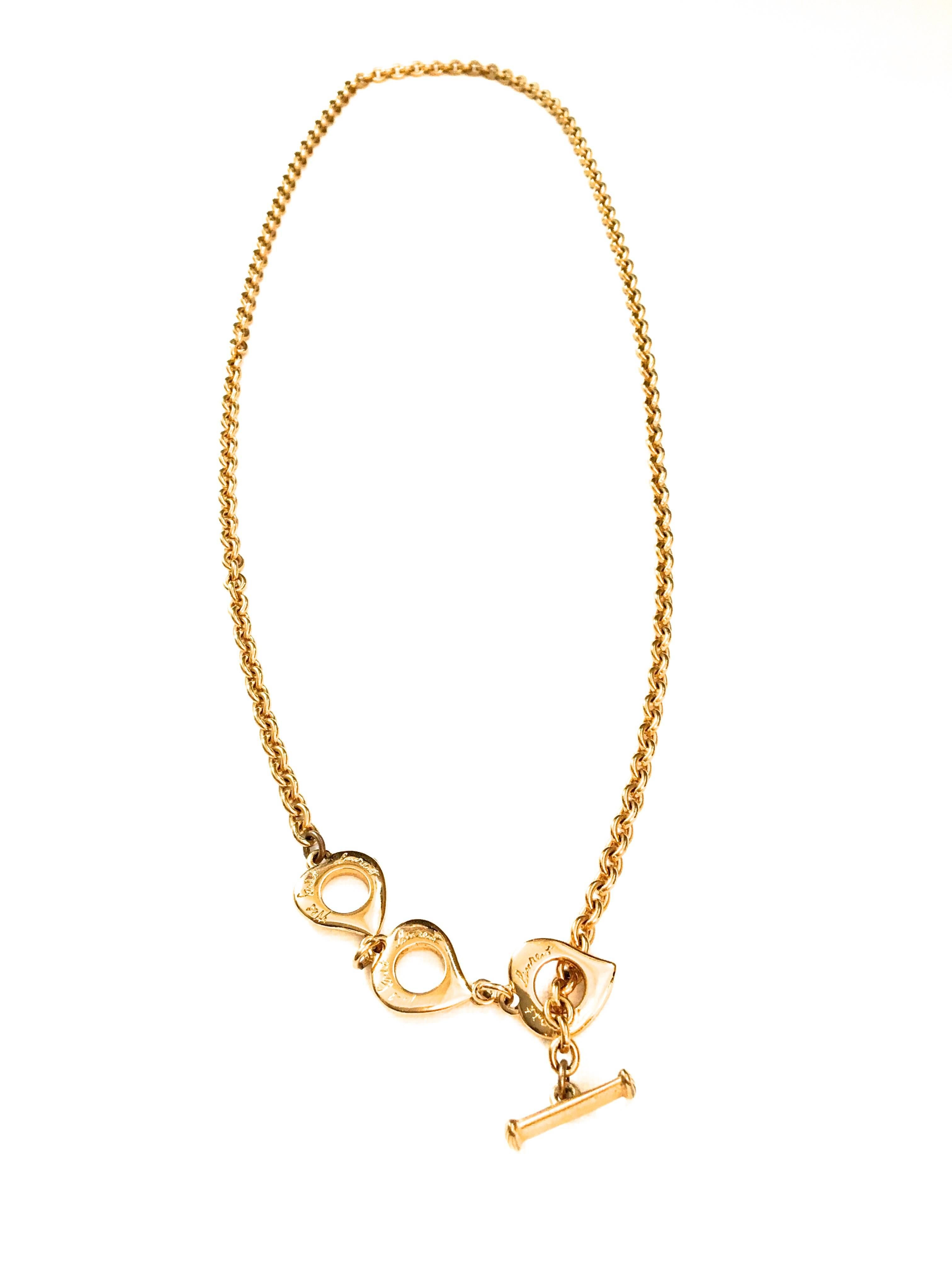 Presented here is a necklace from Yves Saint Laurent. This beautiful necklace is constructed using gold tone metal. The necklace is from the 1980's. The necklace is a gold tone chain with three abstract heart shaped charms connected to the necklace.