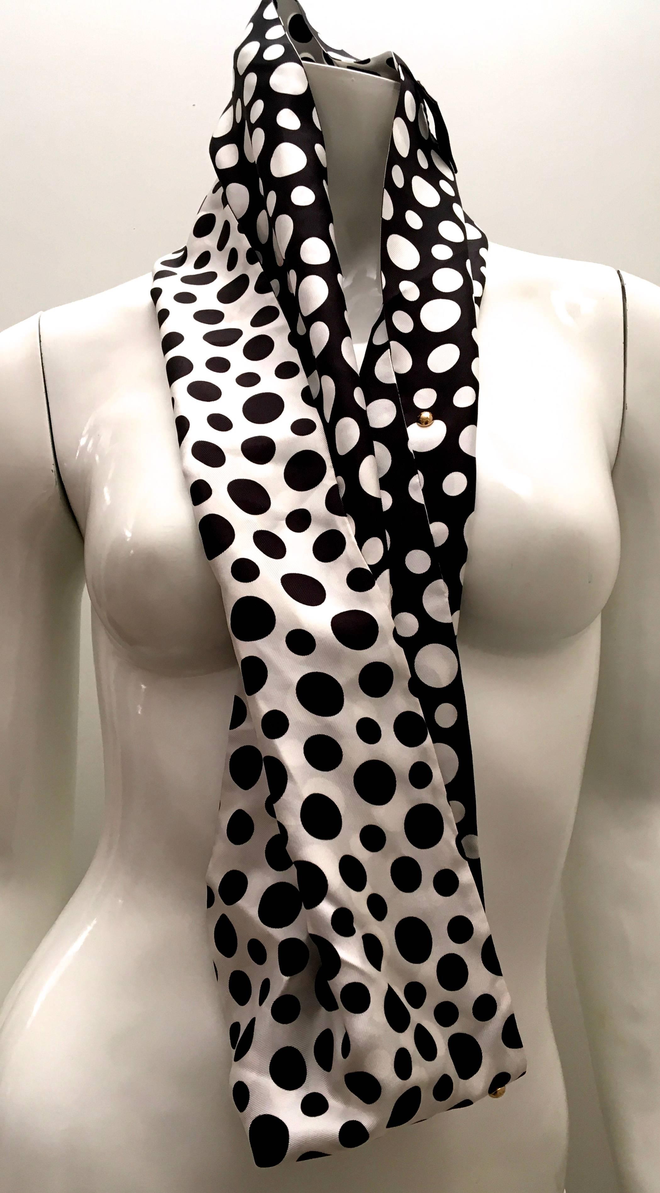 Presented here is a beautiful Louis Vuitton scarf. The styling of the scarf is a snood, so the scarf is sewn on the ends together with a singular twist. The opposite colored design on the back of the scarf with the twist allows for a beautiful and