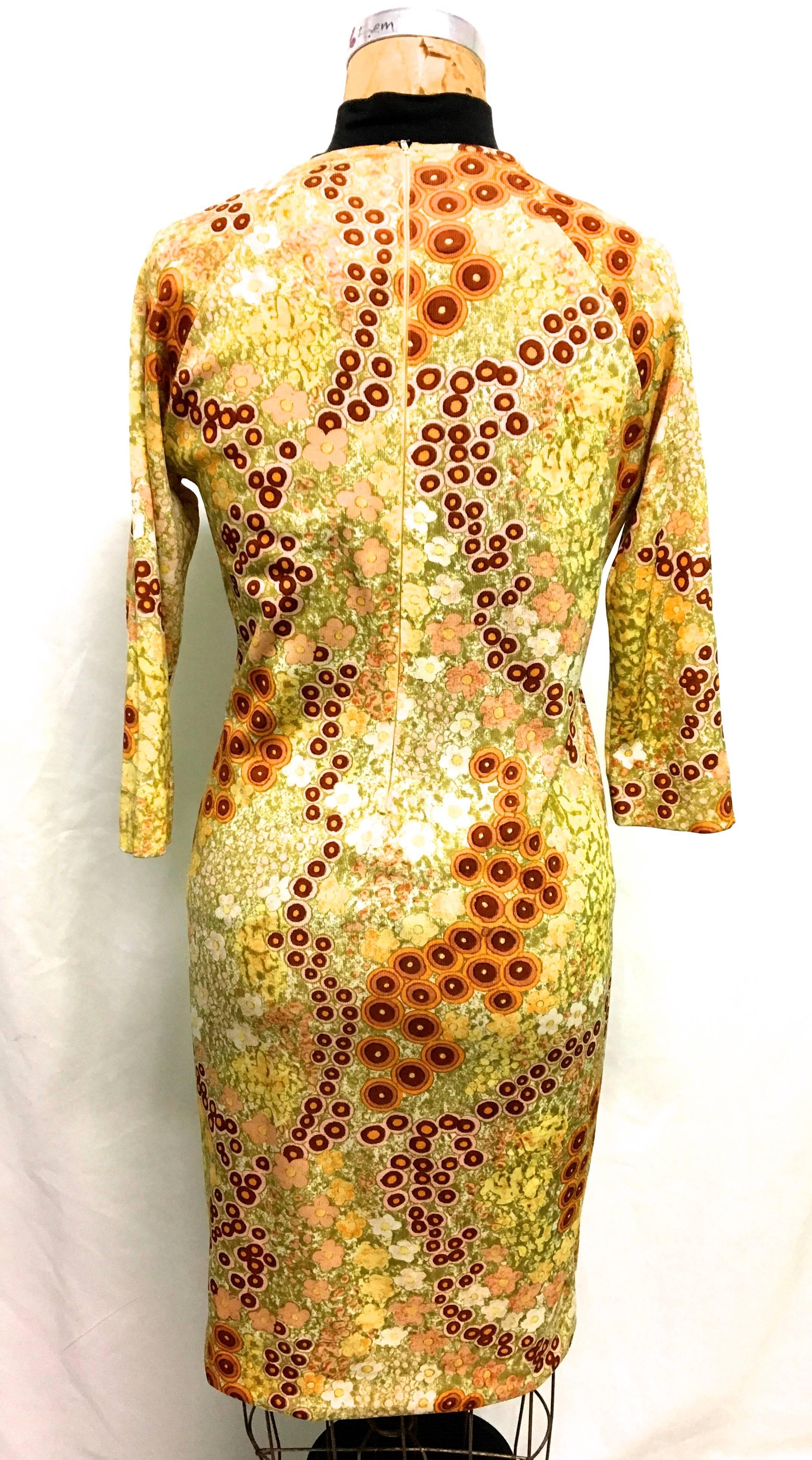 Presented here is a magnificent dress from Goldworm from the 1960's. This beautiful vintage dress is comprised of a floral design of yellows, browns, greens and tans. There is a fabric belt that wraps around the waist of the dress. The dress zips