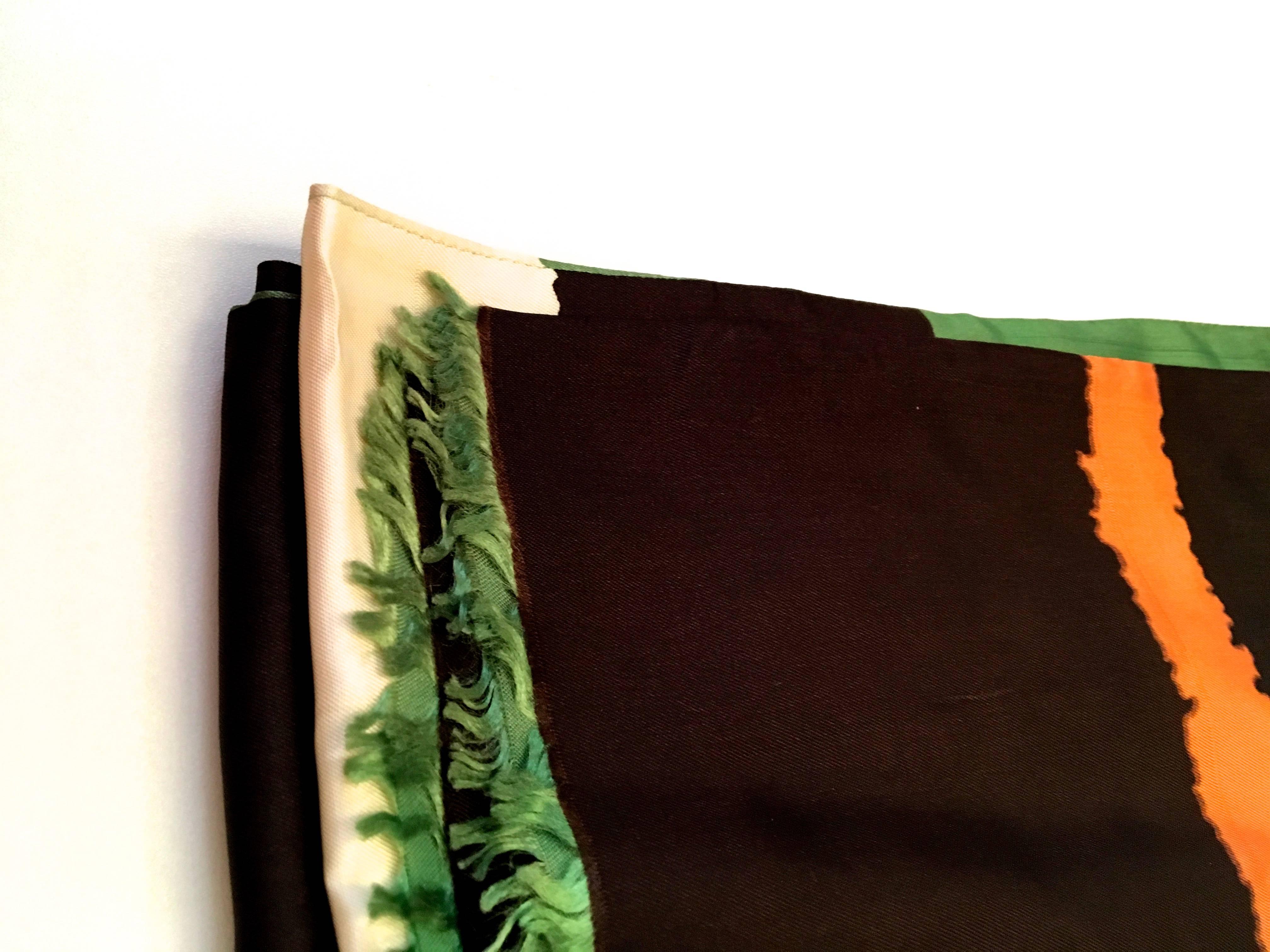Presented here is a beautiful vintage scarf from the 1960's. This scarf is comprised of colors of orange, green, brown and  a cremish white. The colors are each illustrated in a series of thick solid color bars that stretch down the length of the