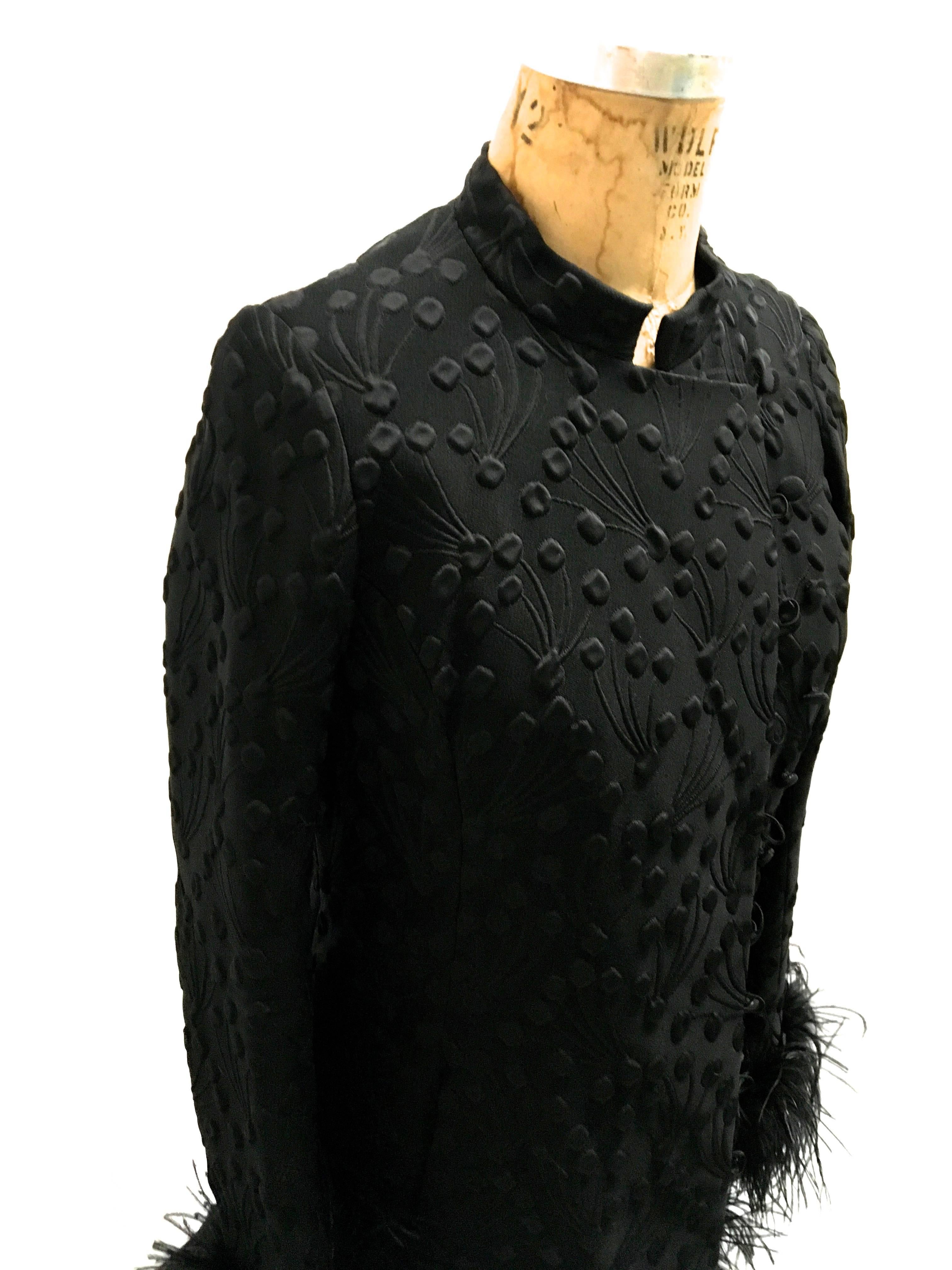 Presented here is a rare coat from Hilary Floyd London. This vintage jacket is from the 1960's. The jacket is comprised of black fabric throughout with black silk textured filigree design work on the exterior of the coat. There are fabulous ostrich