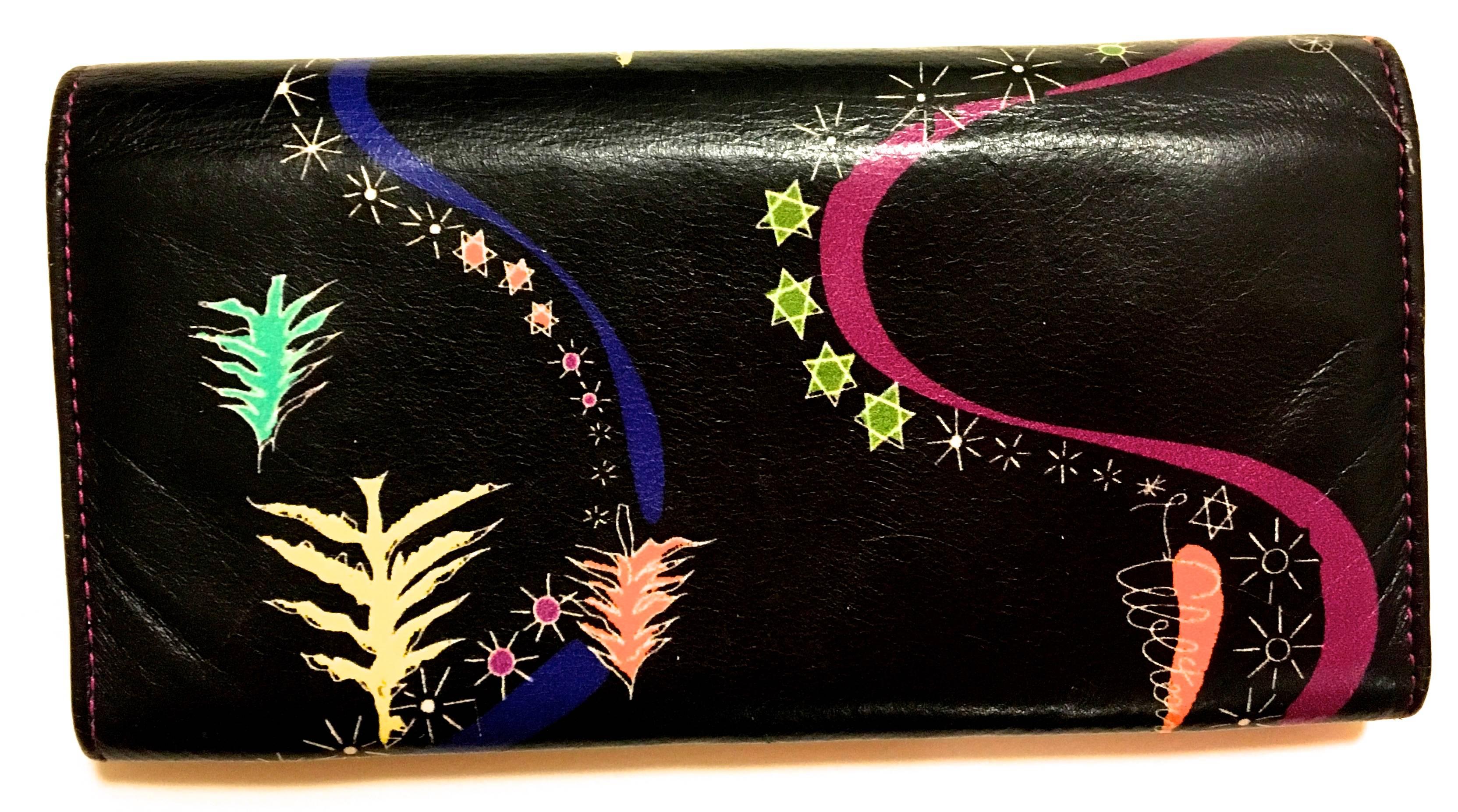 Presented here is a beautiful leather wallet from Emilio Pucci. This extremely rare piece is from the 1990's and beautiful leather is soft to the touch. The design is comprised of a solid black background on the exterior with stars, swirls and
