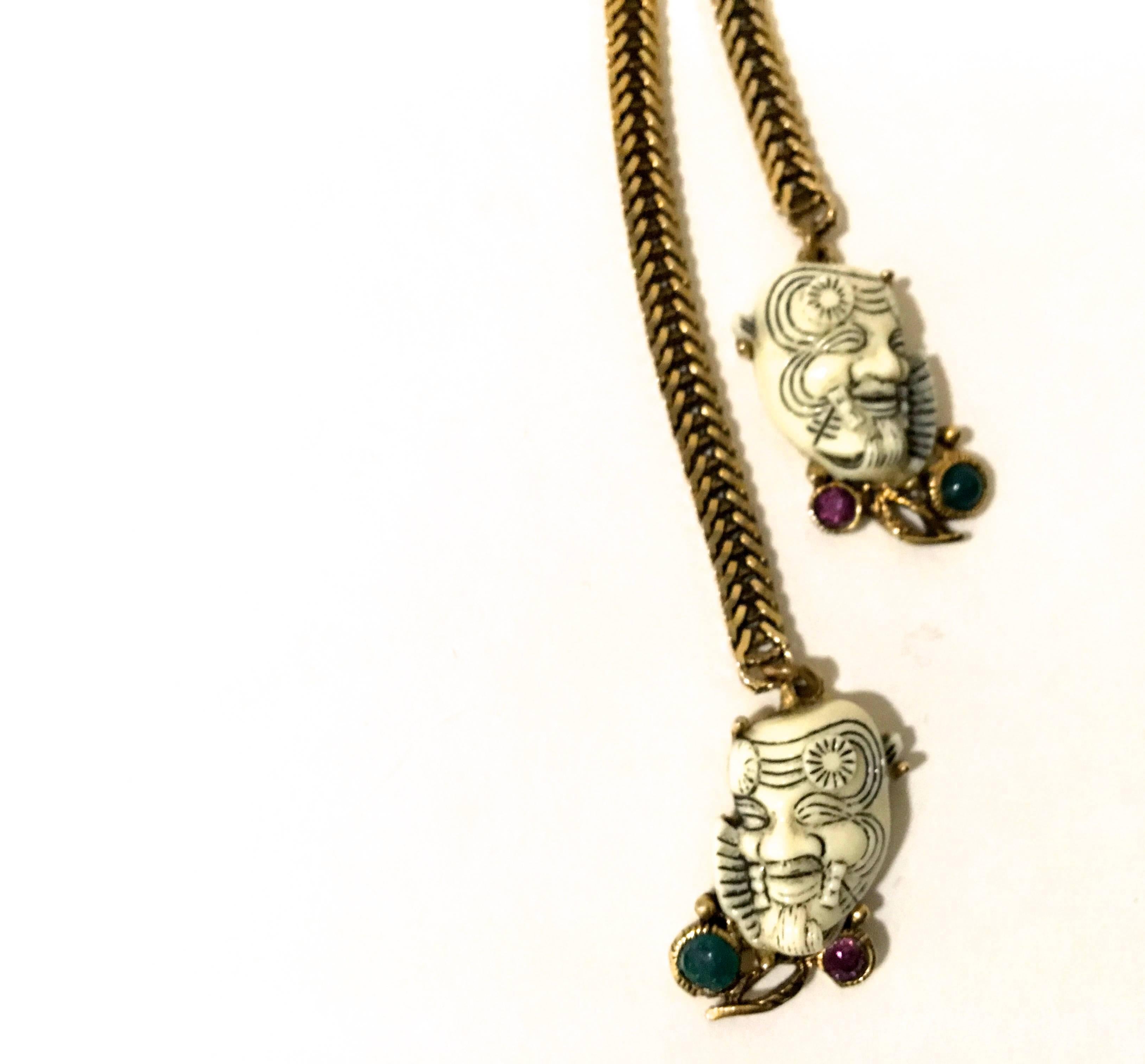 Presented here is a rare necklace from Selro. This beautiful necklace depicts the Asian 'Noh' devil character.  There is a main figurine as the main pendant of the necklace that is surrounded by rhinestones. On the ends of the metal cord there are