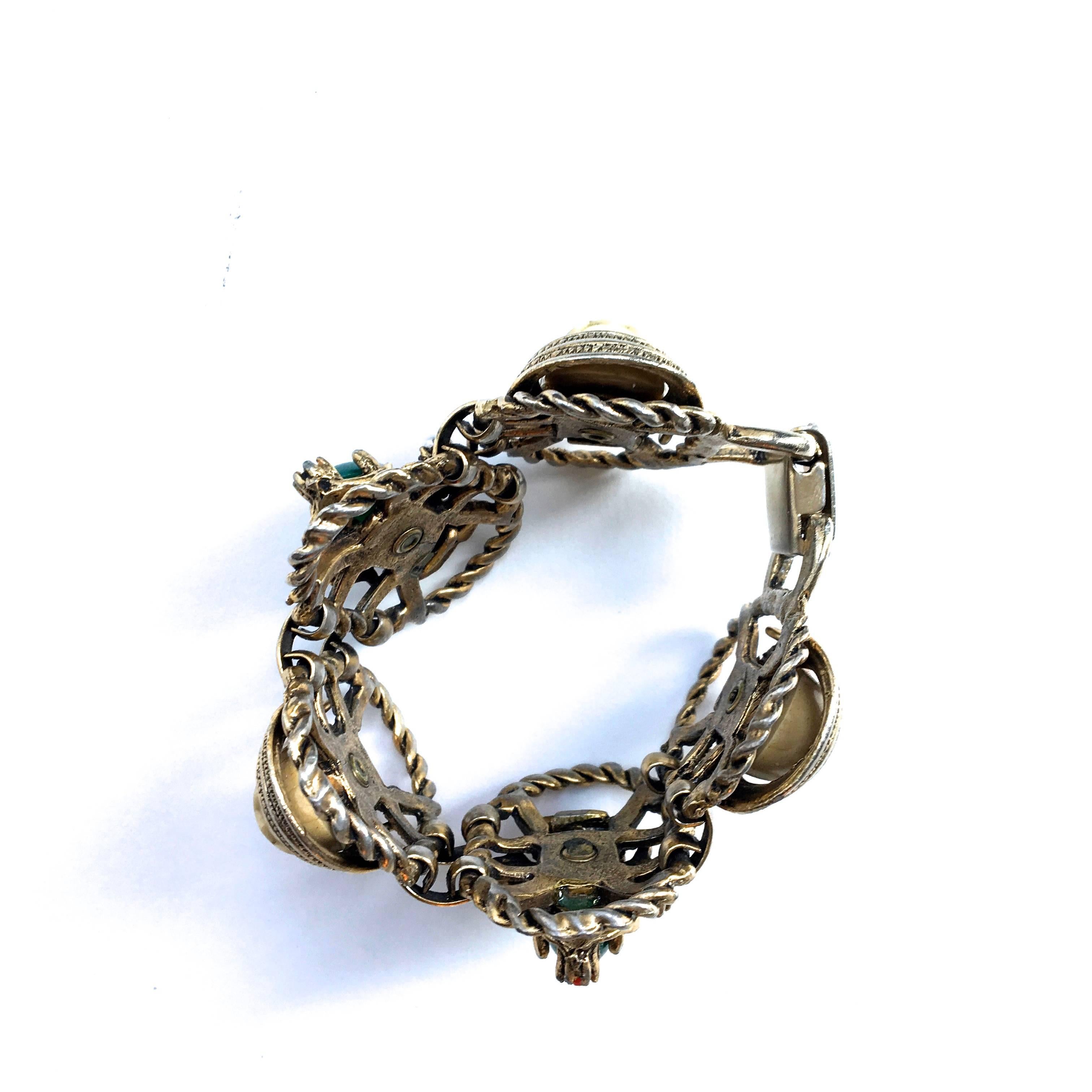 Presented here is a beautiful asian princess bracelet. This beautiful bracelet is comprised of a silver tone metal bracelet frame. Within the links of the bracelet, there are asian princess heads with small pearls adorning the head mask. There are