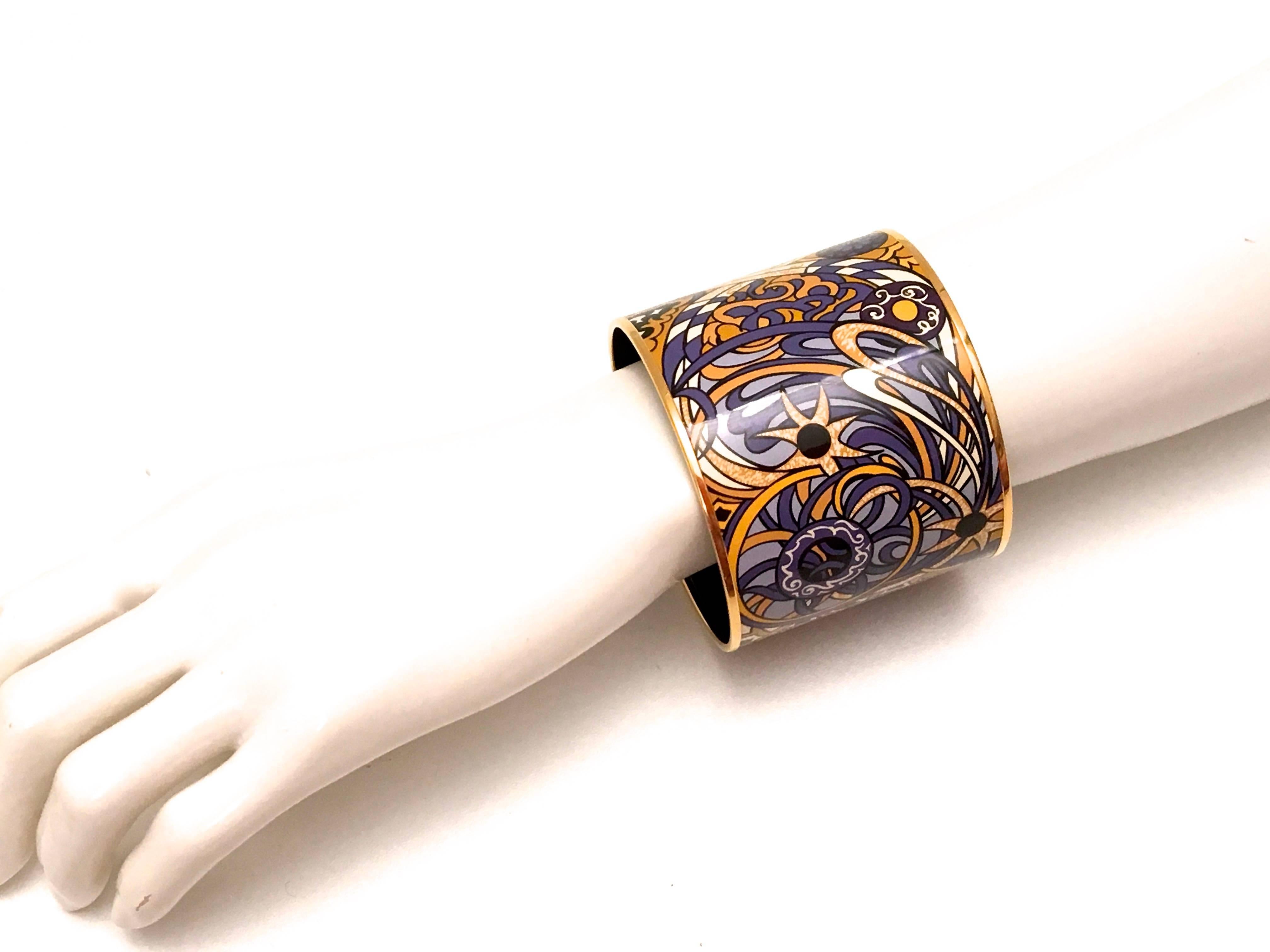This magnificent new Hermes enamel mega bracelet is a real treasure. The bracelet measures 2.5 inches wide and has a diameter of 2.75 inches which is Hermes' GM size. It is a beautiful design which encompasses a pattern of varying shades of purple