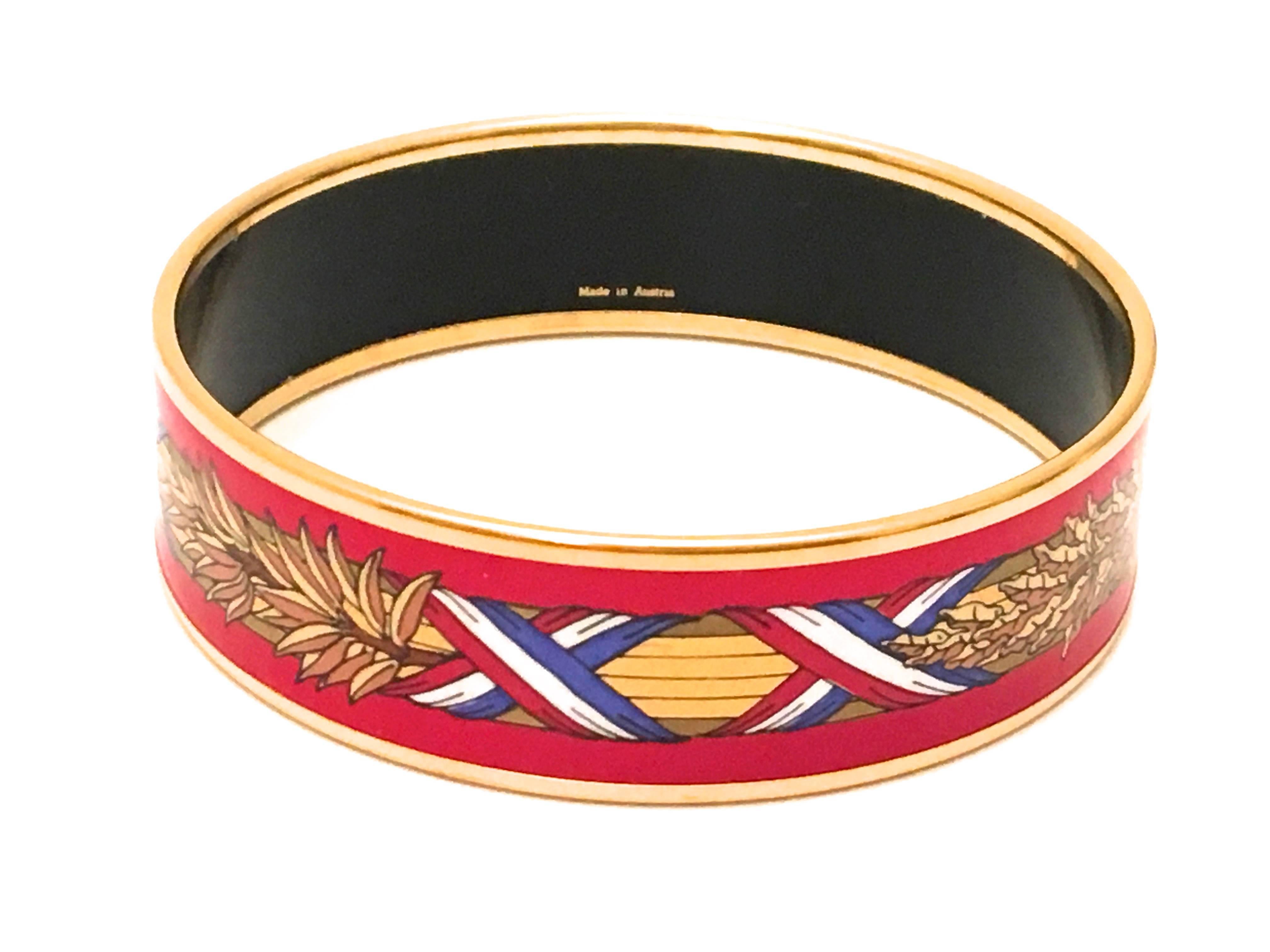Presented here is a beautiful enamel bracelet from Hermes Paris. The bracelet is a GM size which is 2.75 inches in diameter and is a size Large  which is .75 inches wide. The design features a combination of red, white, blue, and gold and is