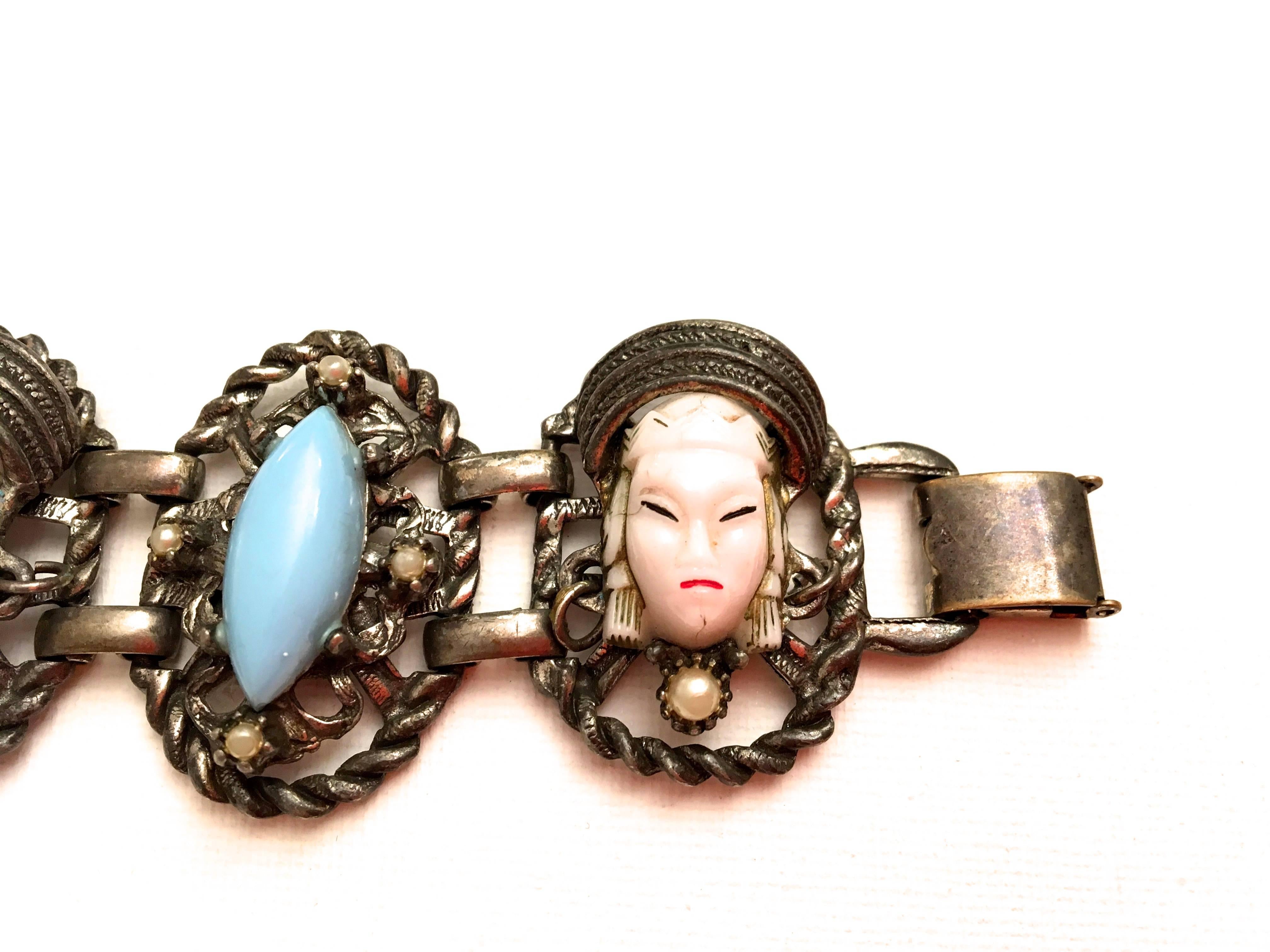 Presented here is a beautiful asian princess bracelet. This beautiful bracelet is comprised of a silver tone metal bracelet frame. Within the links of the bracelet, there are asian princess heads with small pearls adorning the head mask. There are