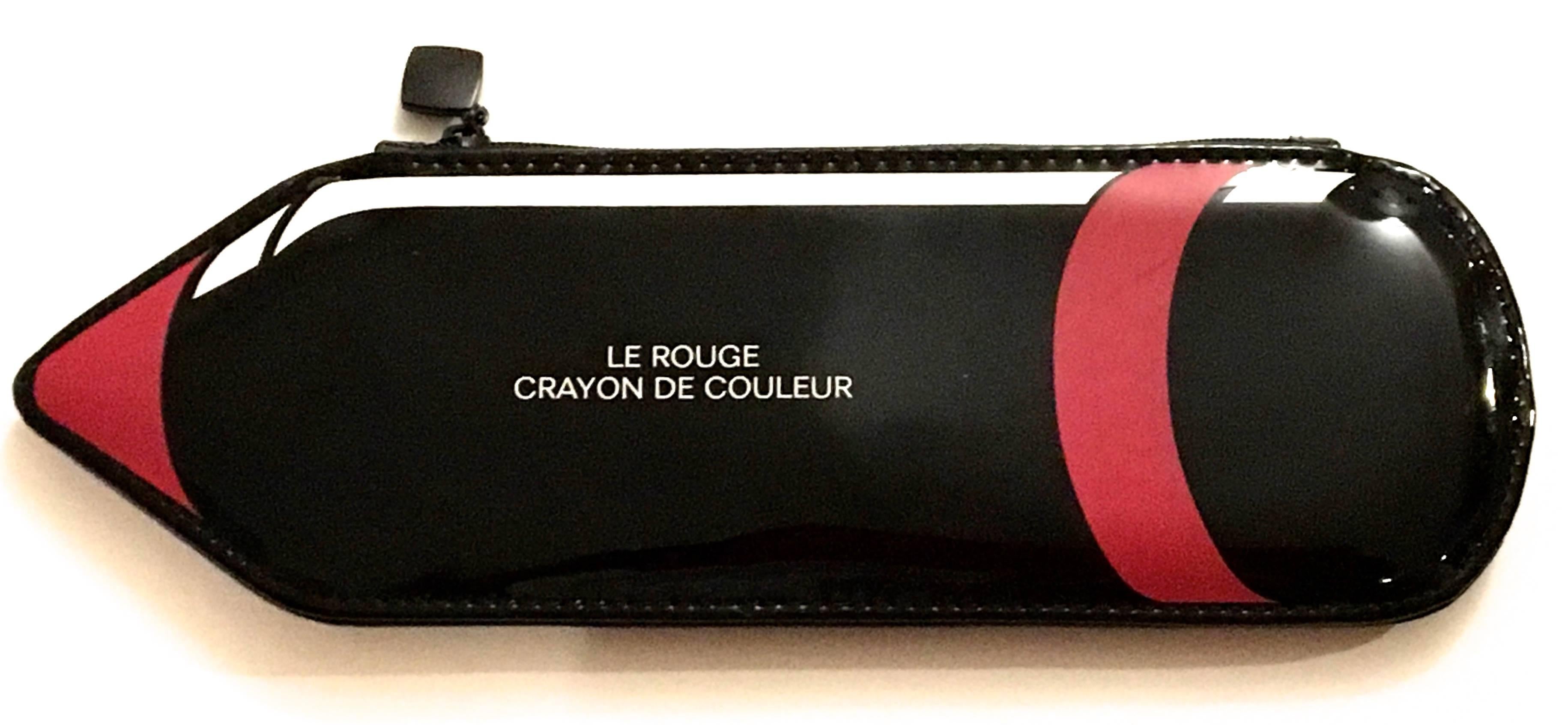 Presented here is a makeup / cosmetic bag from Chanel. This beautiful little cosmetic case is made from patent leather that has been made into the shape of a pencil. The coloring of the bag is a black pencil with a red tip. The makeup case is signed