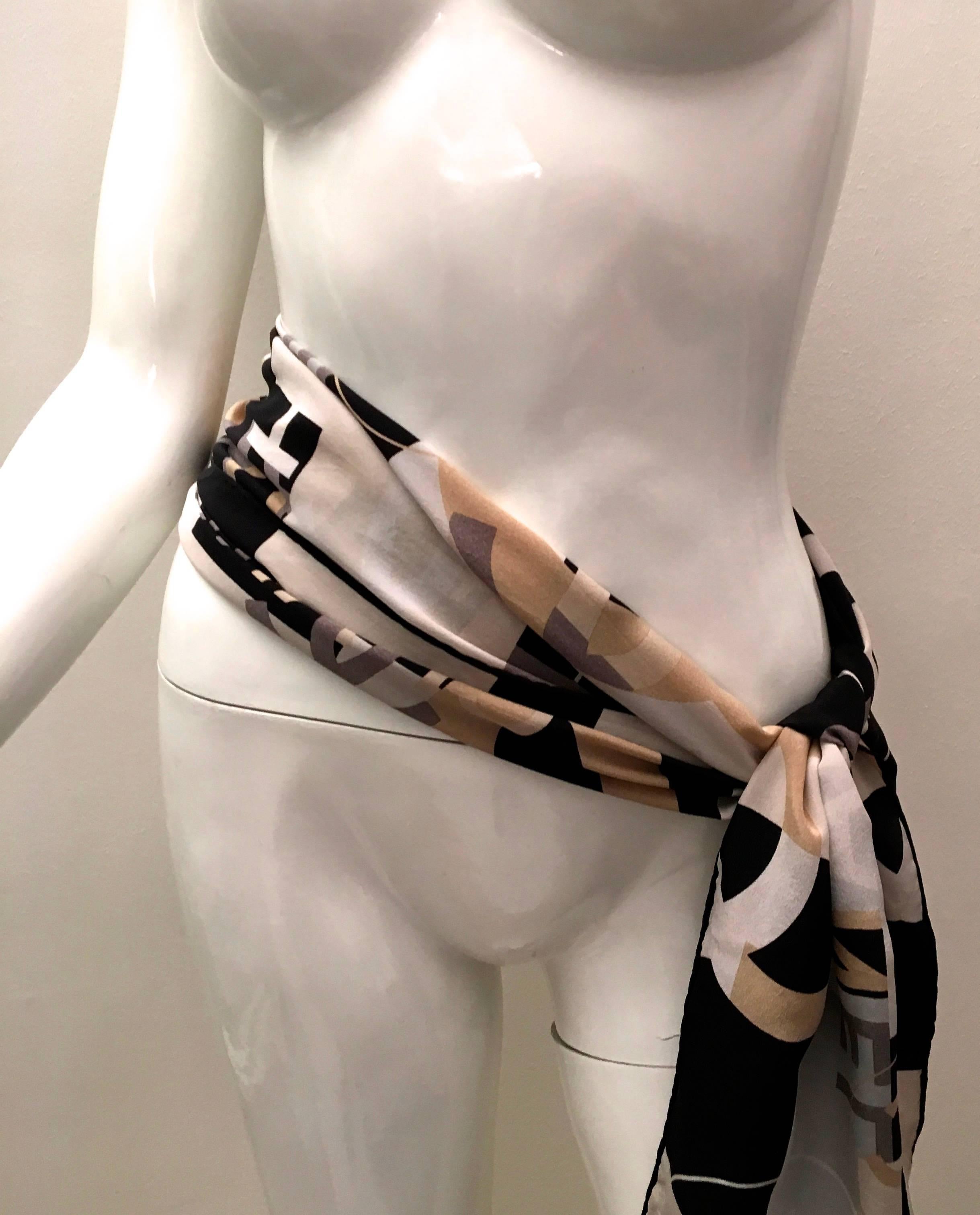 Presented here is a fabulous scarf from Chanel. This gorgeous scarf is made from soft 100% silk material and is hand-rolled. The scarf’s design is an abstract arrangement of the Chanel name and iconic CC emblem in a series of colors of creamy white,
