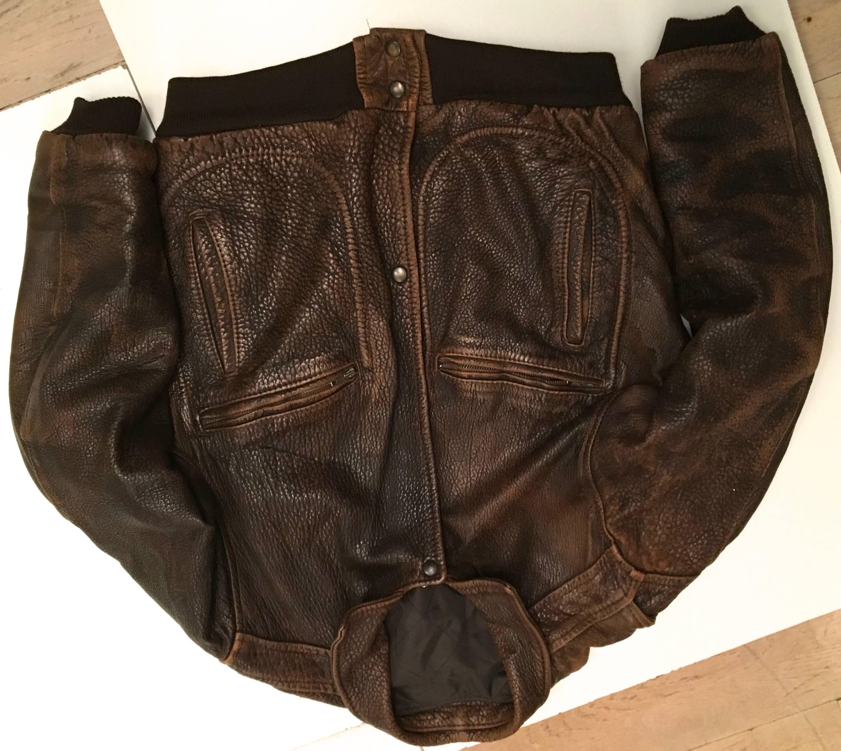 Presented here is a men's bomber jacket from the 1980's. This jacket is comprised of a beautiful brown leather on the exterior and brown fabric lining on the interior. There are four pockets on the front of the coat: two zipper pockets and two open