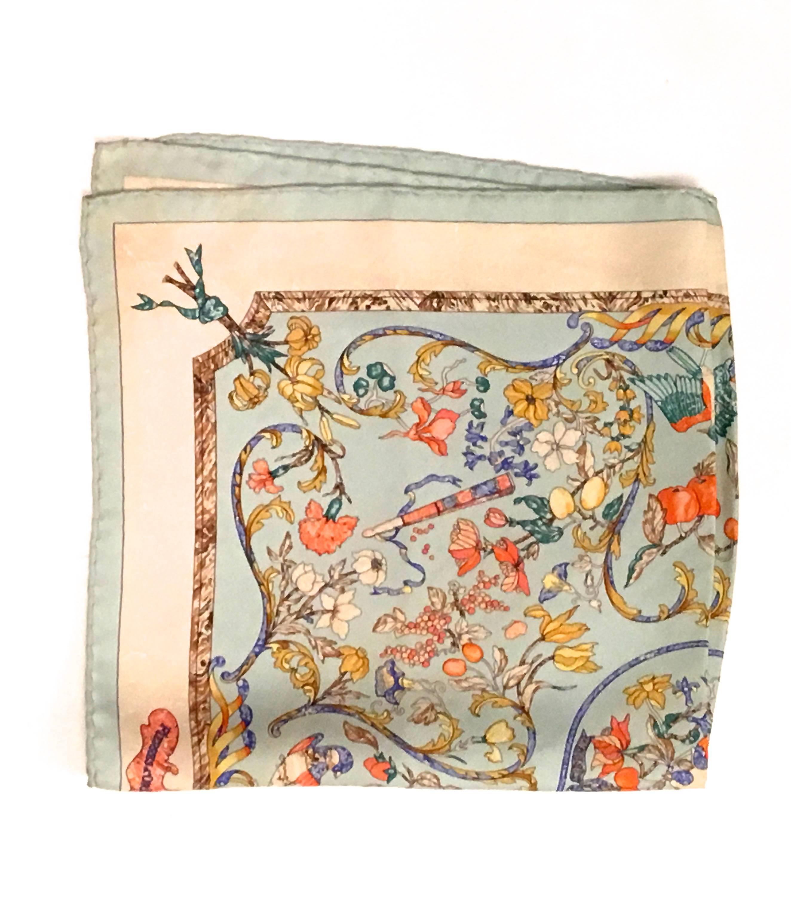 Presented here is a gorgeous vintage scarf from Hermes Paris. This beautiful scarf has a floral design that also has birds implemented as well. The color scheme incorporates shades of blue, red, yellow, purple, green, creamy white and brown.