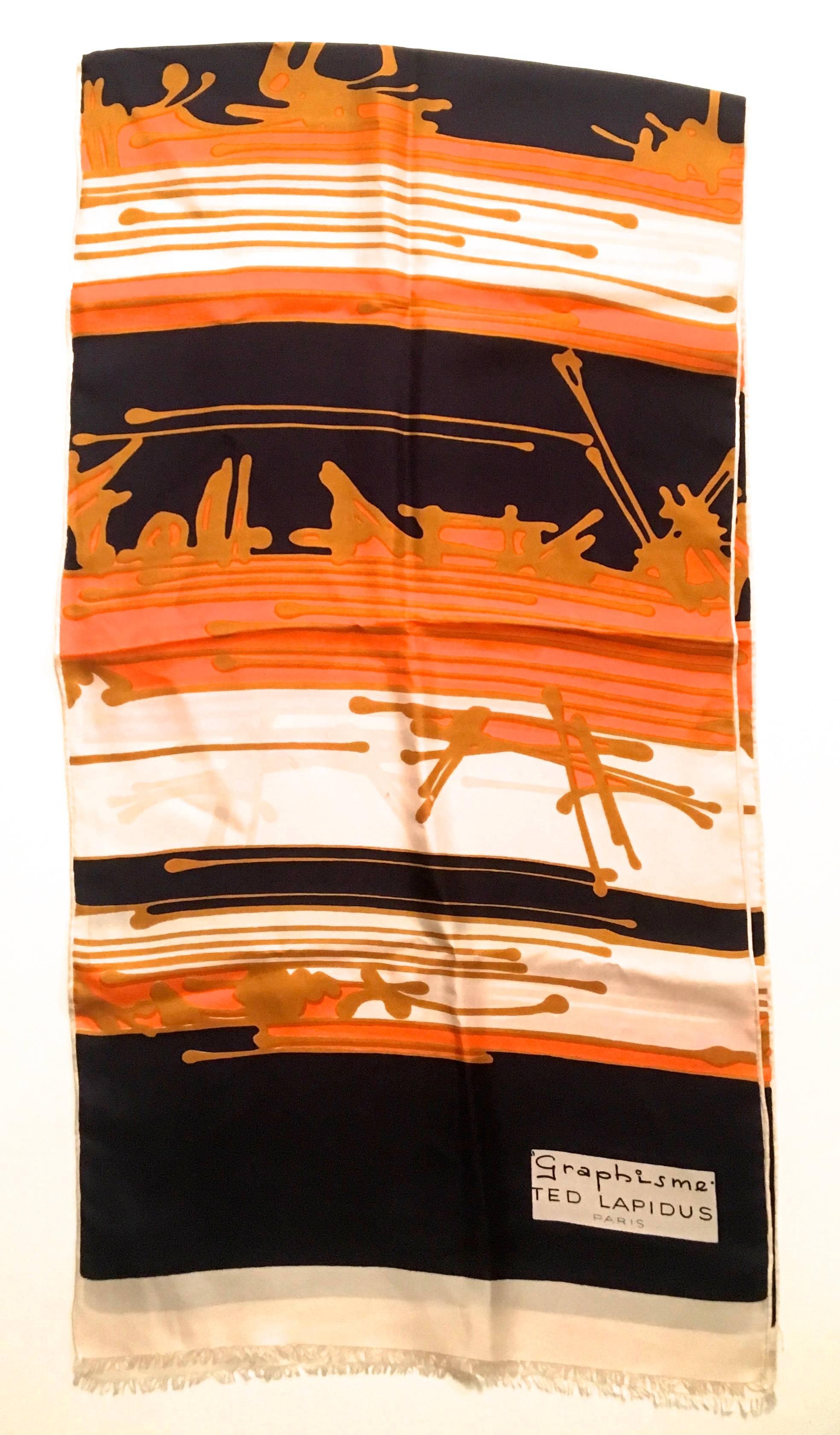 Presented here is a scarf from Ted Lapidus. This vintage scarf is from the 1970's and is in near mint condition. The scarf design is an abstract design comprised of colors of white, black, orange and gold. This rare scarf is signed by Ted Lapidus in