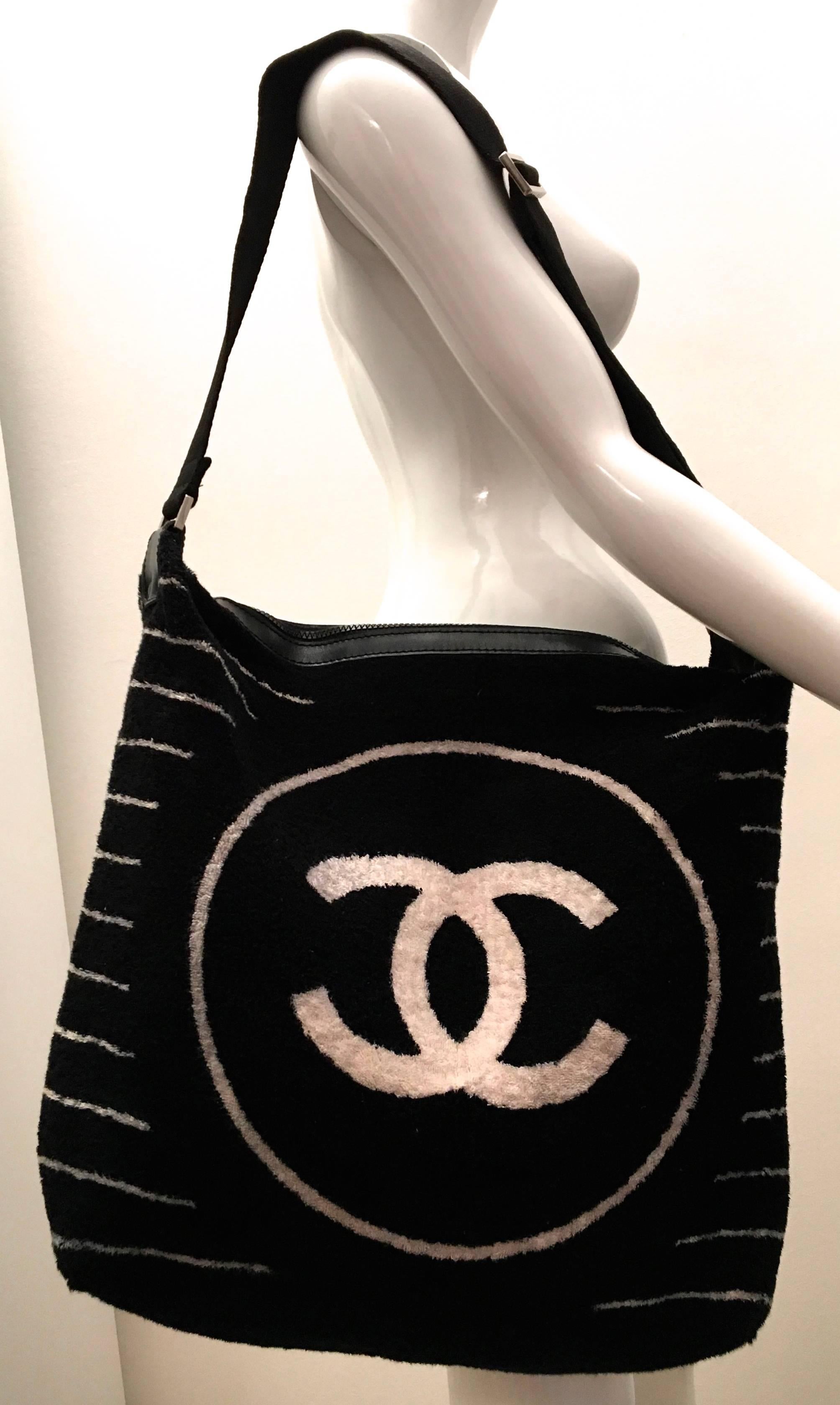 Presented here is a rare Chanel black terry cloth shoulder bag. This fantastic bag has a singular main compartment that has sufficient storage room for most normal necessities for a day out. There is a small pouch at the top the bag. The exterior