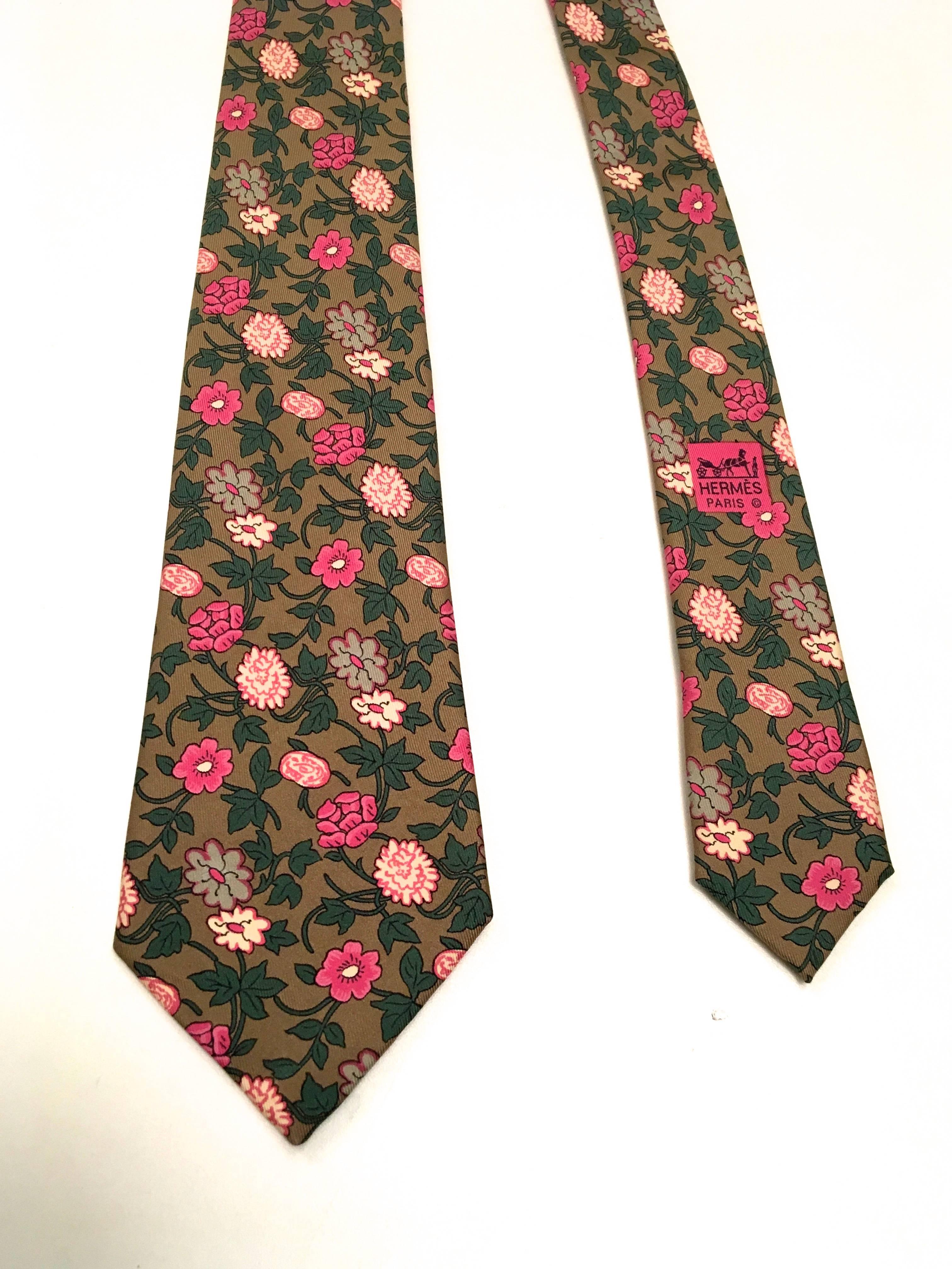 Presented here is a beautiful necktie from Hermes Paris. This vintage neck tie is a floral print in colors of pink, magenta, green and brown. At its wide point, the tie measures 3.5 inches.  It is in excellent condition. The tie is made in France. 