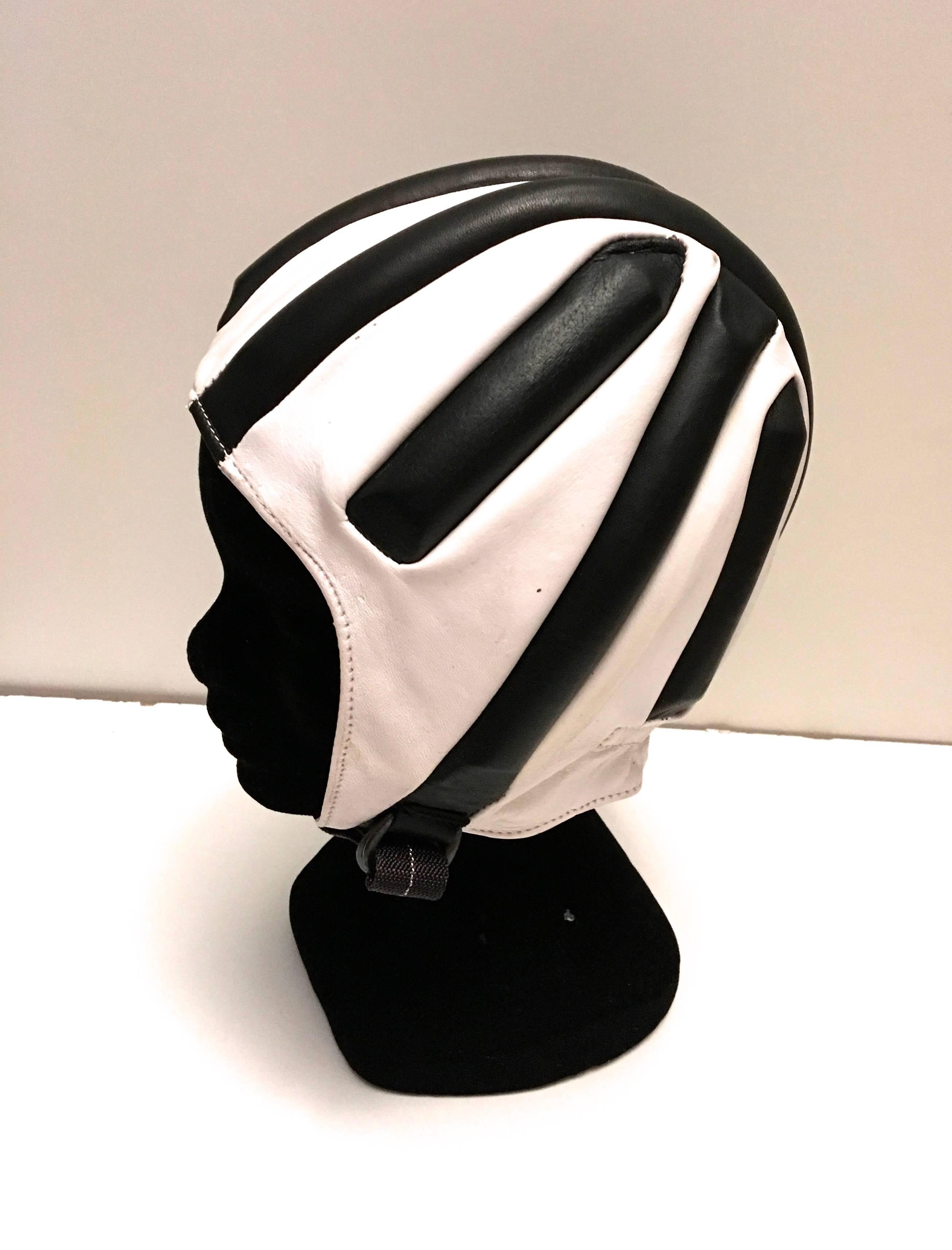 Presented here is a racing cap / helmet from the Italian manufacturer, Boeri. This fantastic helmet appear to have never been used. It still has its original box. The helmet is comprised of black and white leather with protective padding built