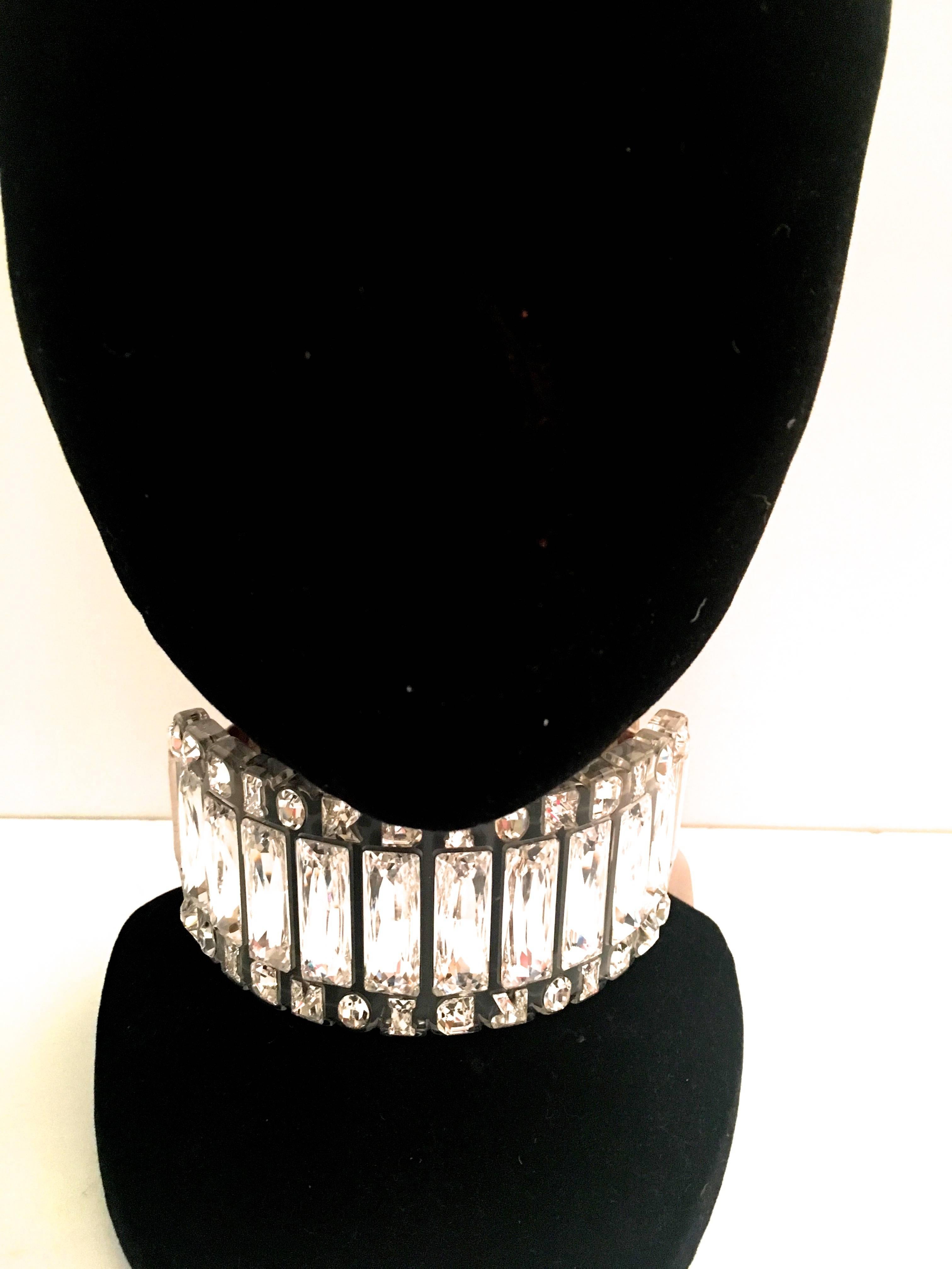 Presented here is a fabulous Christian Dior runway choker from the 1990's. This rhinestone choker necklace is comprised of a series of long baguette rhinestones across the front of the necklace. Bordering the top and bottom, DIOR is spelled out in