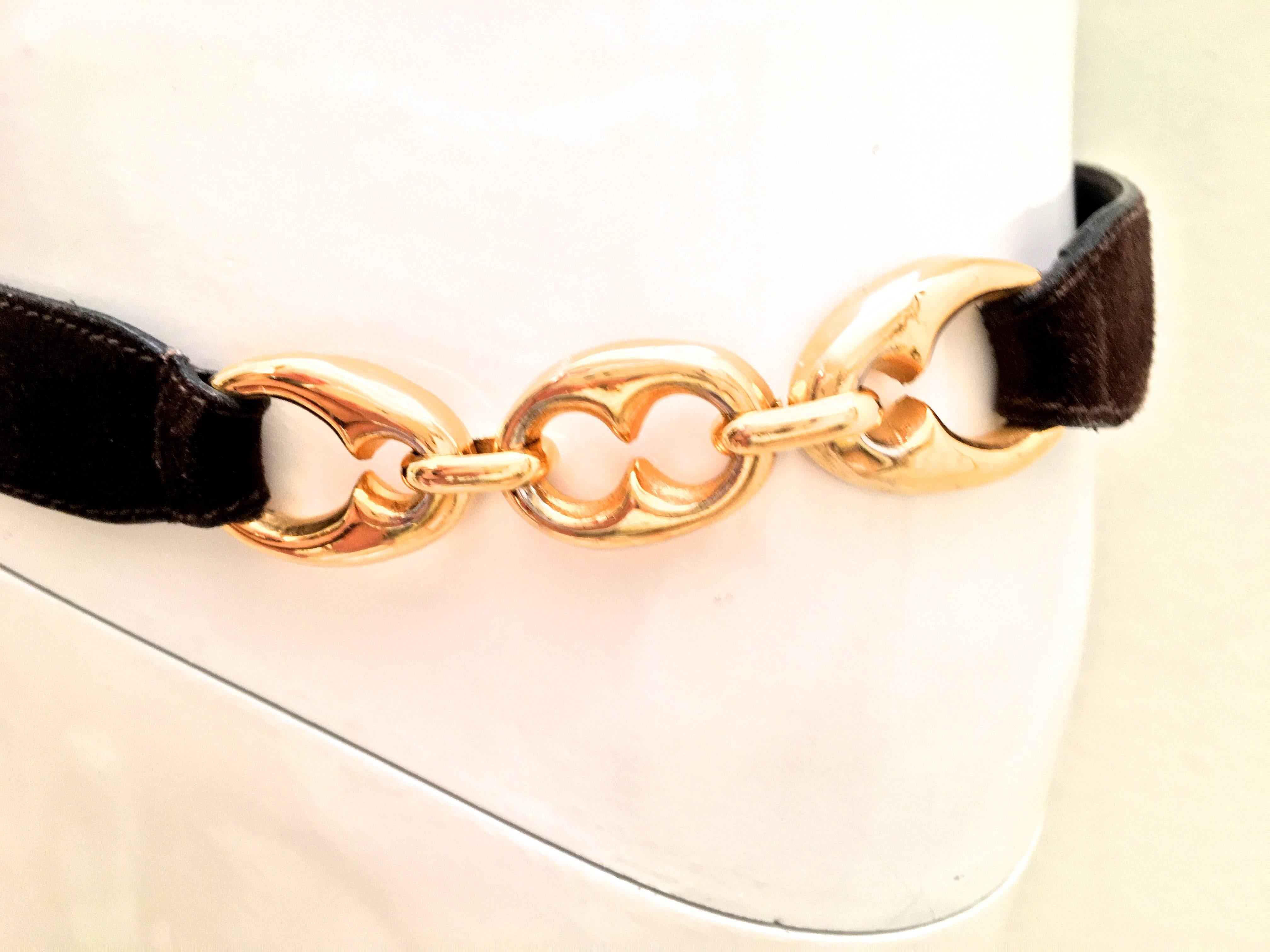 Presented here is a beautiful Celine vintage belt with gold tone links and brown suede. It is marked on the inside 'Celine Paris' size 80. Although the belt is adjustable because of a grommet that can be placed into different holes on the belt. The