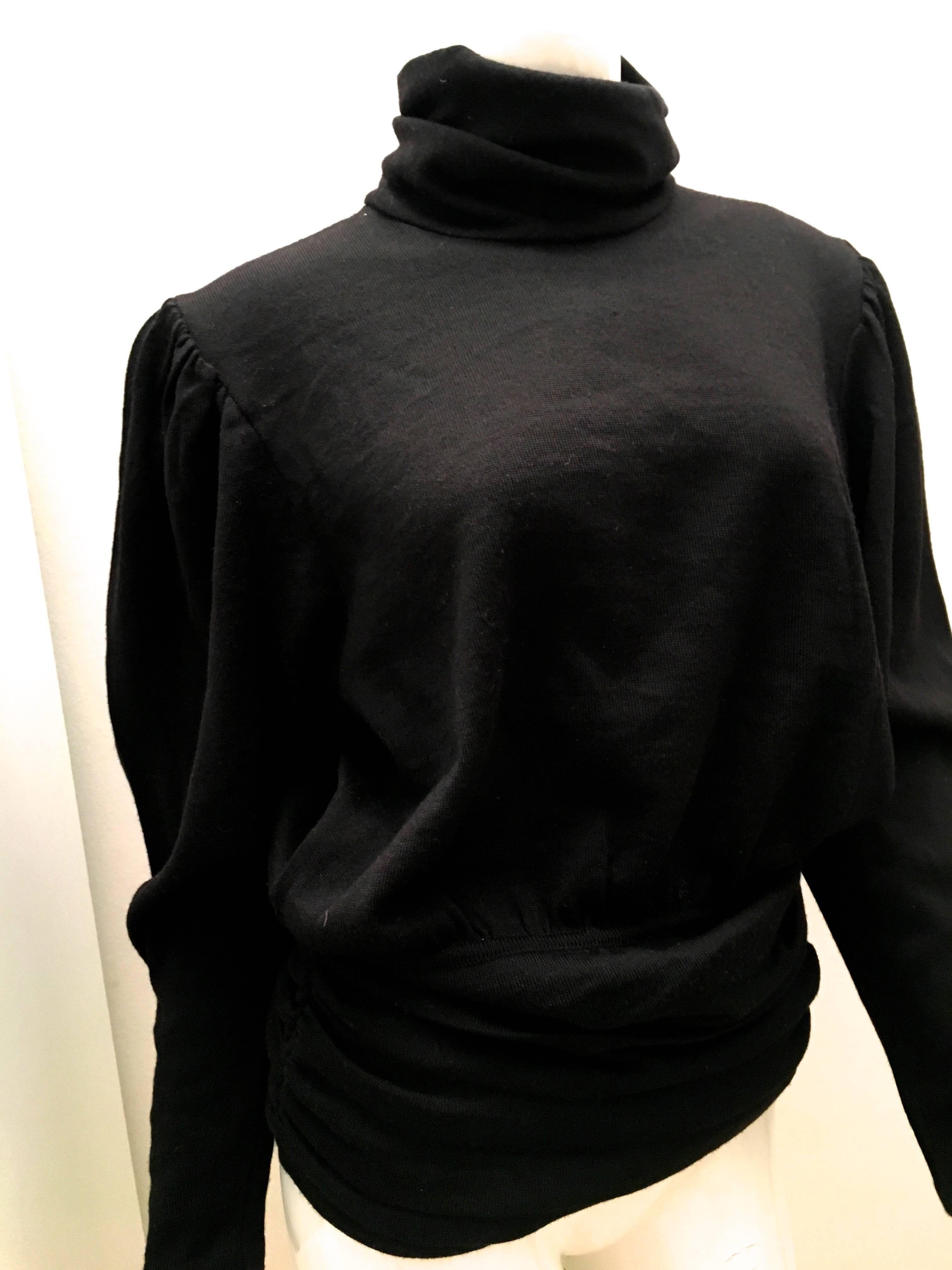 Presented here is a beautiful black sweater from Valentino. The sweater has a turtle neck and is comprised of gathered fabric on sweater to create body to the scarf. Made in Italy. 100% Wool. Please see below for details of measurements. The sweater