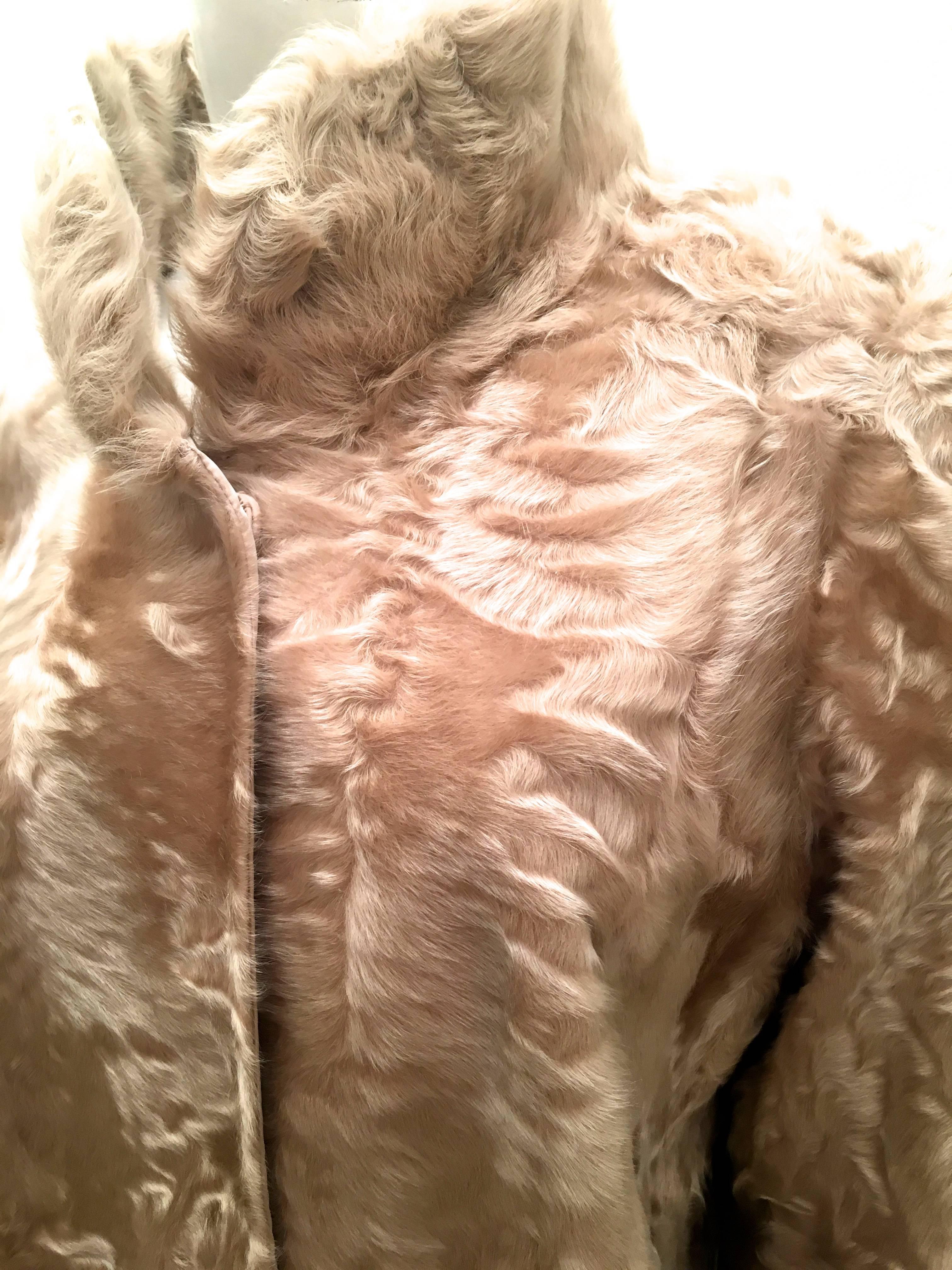 Presented here is a fabulous women's fur coat. This gorgeous coat is made from a beige lamb hair from Africa known as 'swakara.' The coat on the reverse side is made entirely from a silk taffeta. The coat is fully reversible and can be worn on