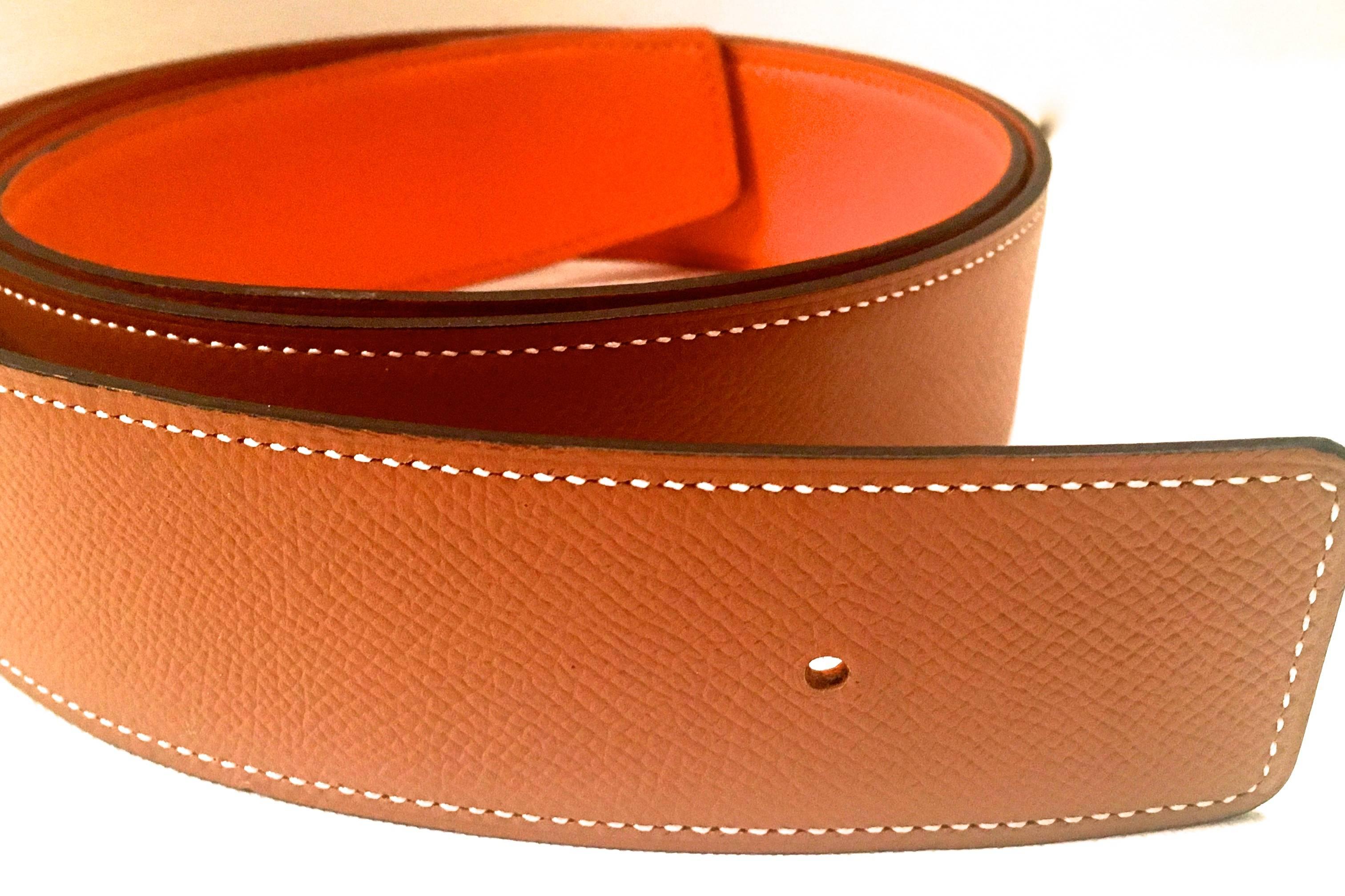 Presented here is a beautiful leather strap from Hermes Paris. The strap is comprised of epsom leather on both sides of the strap. The strap is reversible and can be worn with either color. The strap is orange on one side and Hermes gold which is a
