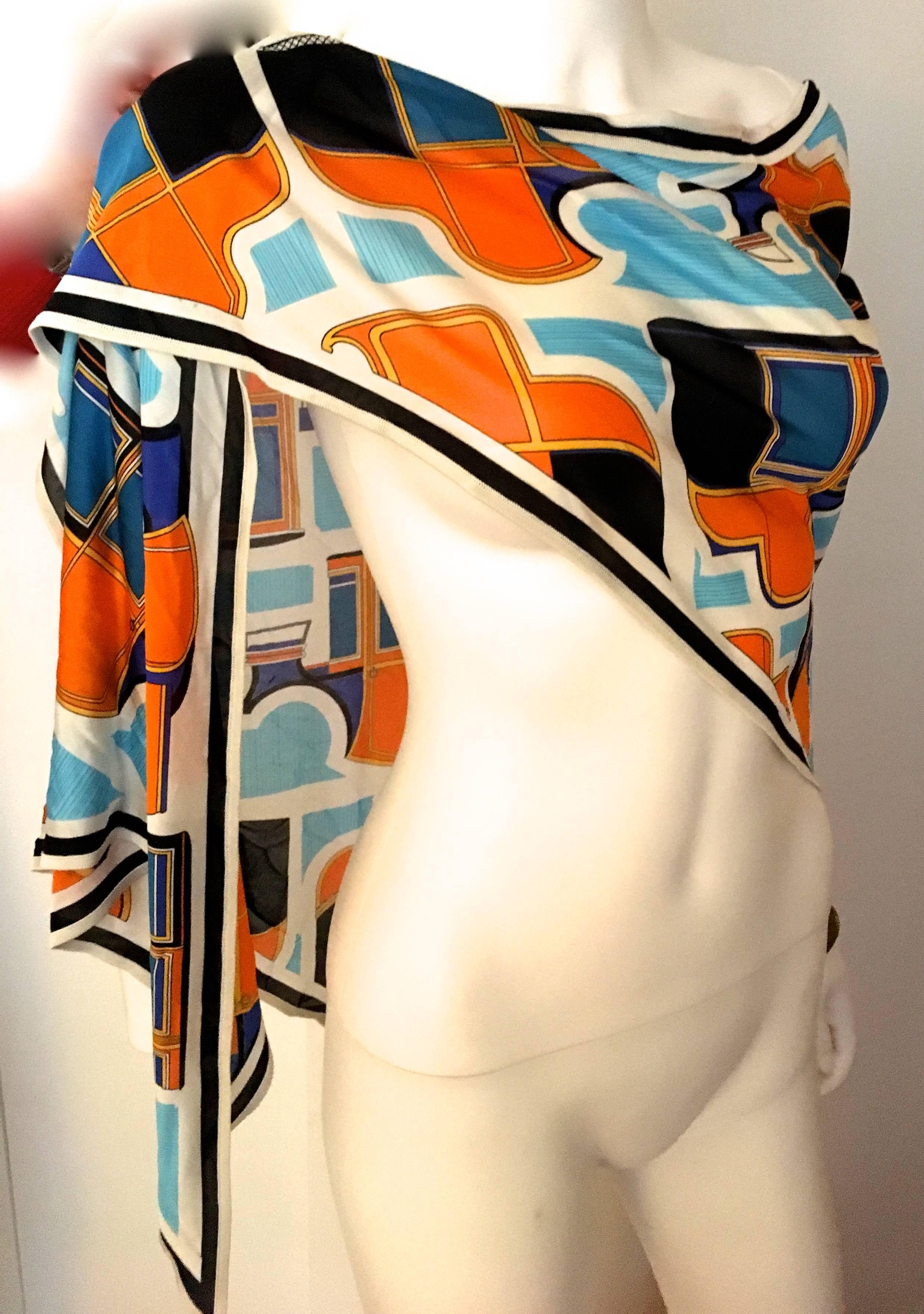 Presented here is a rare scarf from Hermes Paris. This beautiful scarf is significantly larger than the typical scarf from Hermes Paris and is more of a shawl size. The scarf is made from silk jersey and is a composition of abstract geometric horse