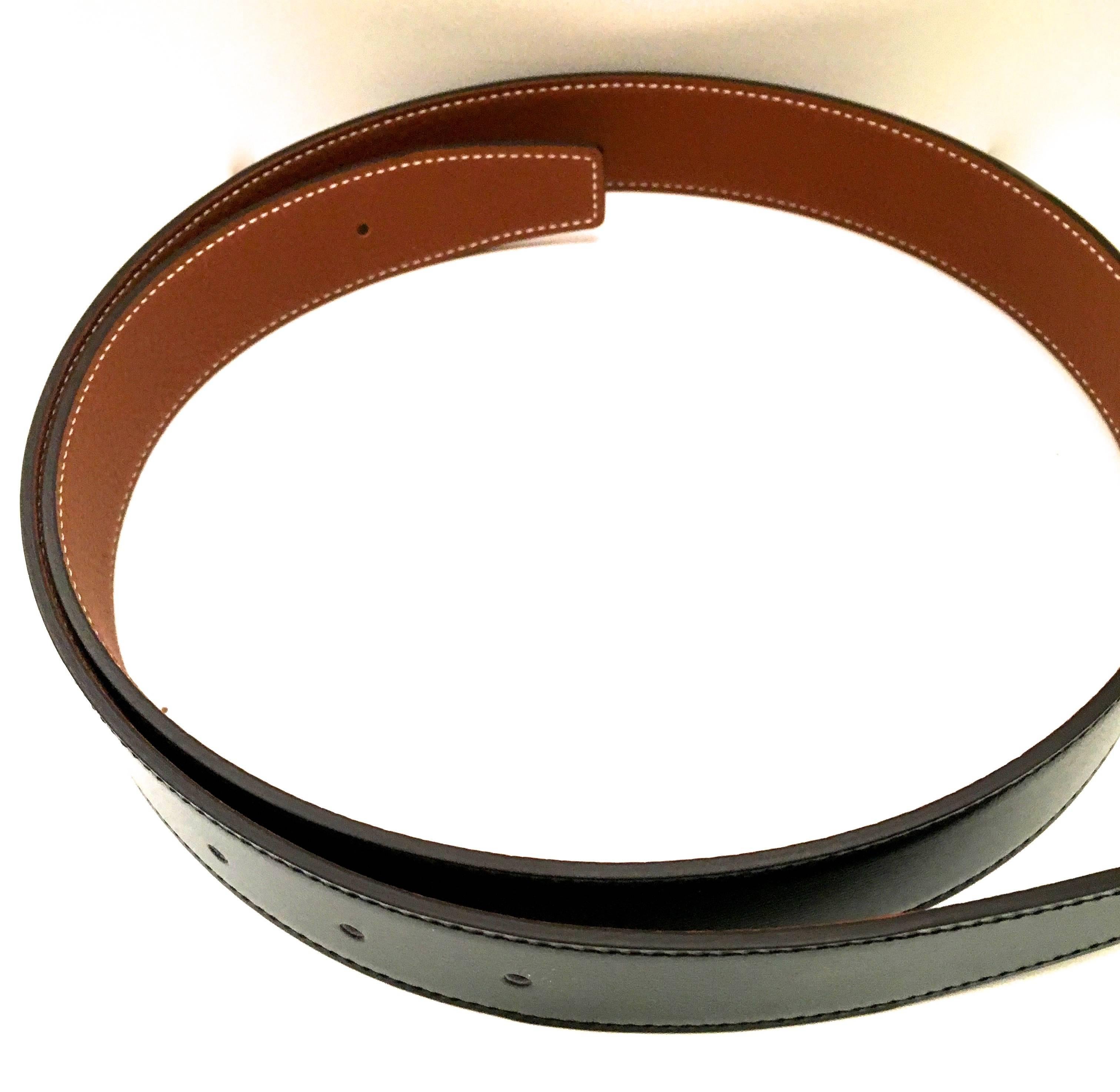 Presented here is a leather belt strap from Hermes Paris. The strap is a size 85, which is 33.5 inches in total length. This leather strap is smooth black box leather on one side and gold clemence leather on the reverse side. The strap is fully