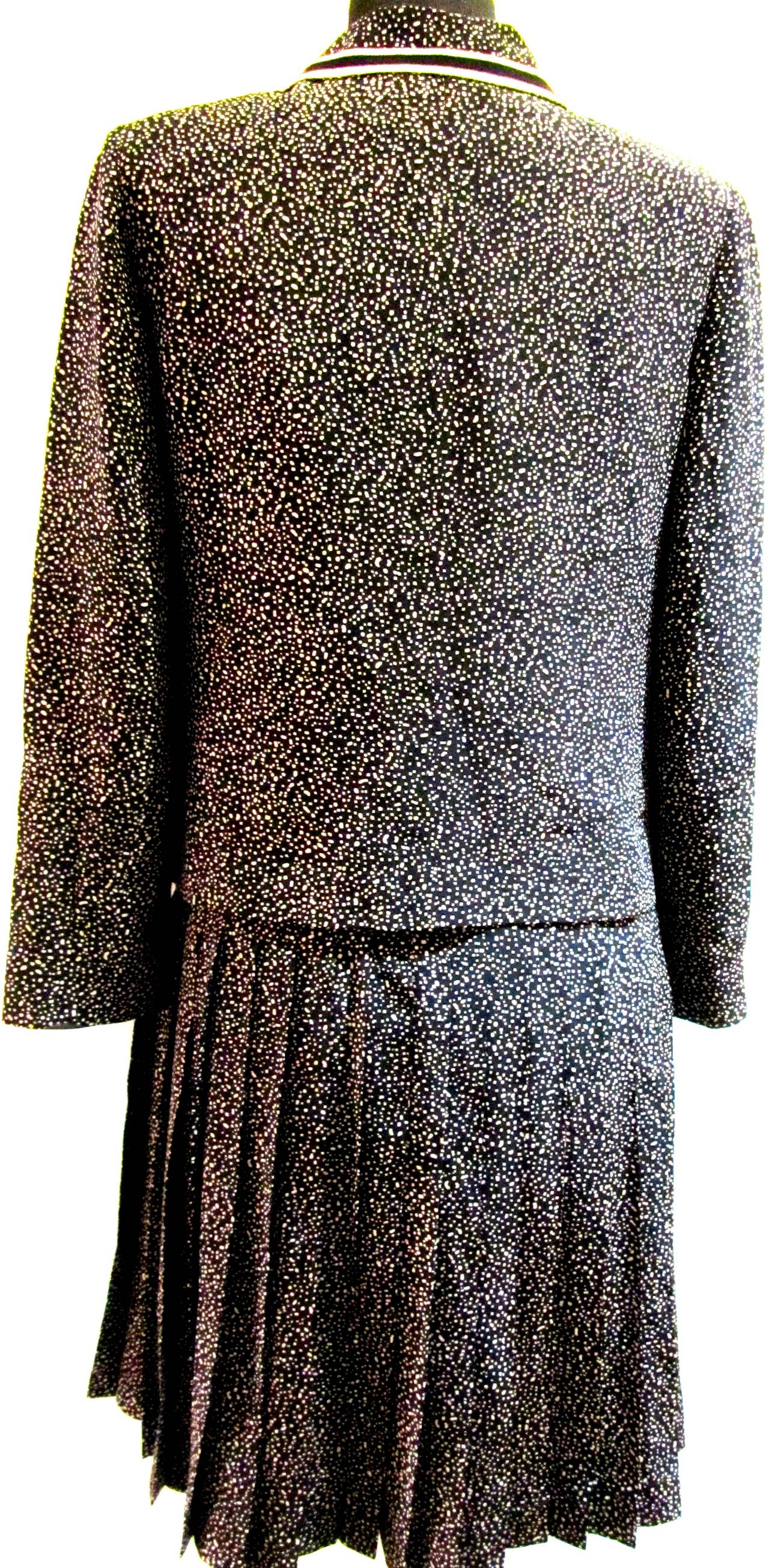 Vintage Chanel Boutique silk suit. Cream colored dots on black fabric with stripe trim. The suit has rare iconic gold and black lion's head buttons. The elastic waist band of the skirt has been replaced by Chanel. Rare suit from the 1970's that is