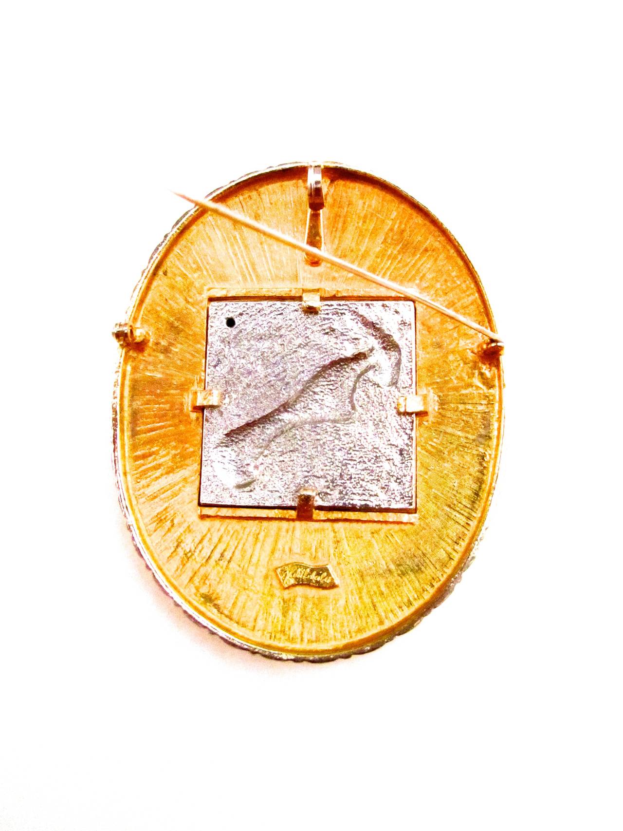 Vintage Judith Leiber Ram pin/brooch. Pin has a zodiacal ram on the cover. The pin's measures 4 inches by 3 inches. The exterior is a gold tone metal and the interior is a silver toned encased metal with the ram symbol. Very gorgeous and rare