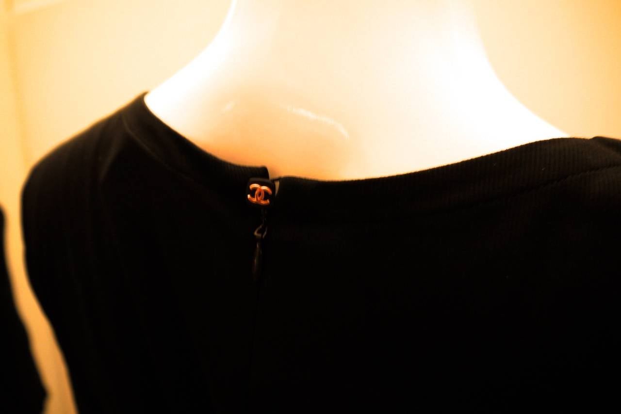 Presented here is a beautiful, elegantly simple Chanel Boutique black top. It has almost a full zipper down the back and quietly has a black square button closure with gold tone CC logo. The photographs do not do this top justice. It looks