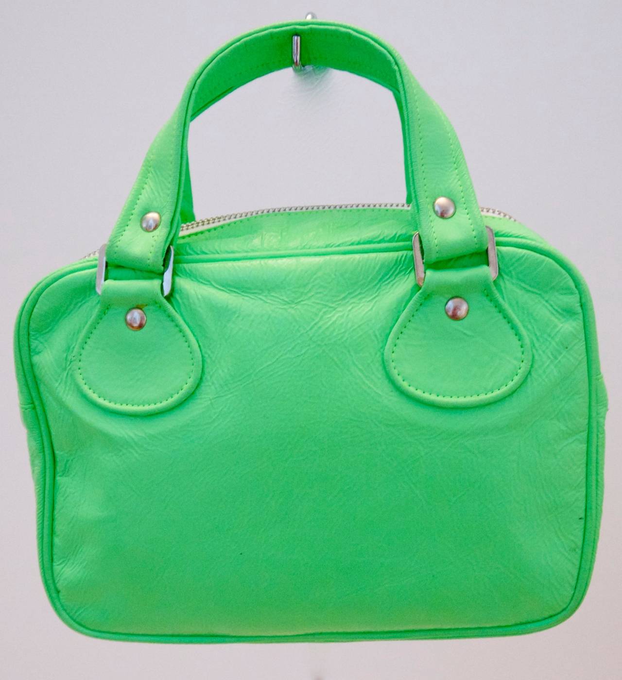 Courreges green small tote bag. The bag has a zip closure at the top and still possesses its original certificate of authenticity. It's in remarkable condition considering its age. The plastic material on the exterior of the bag is in clean fresh